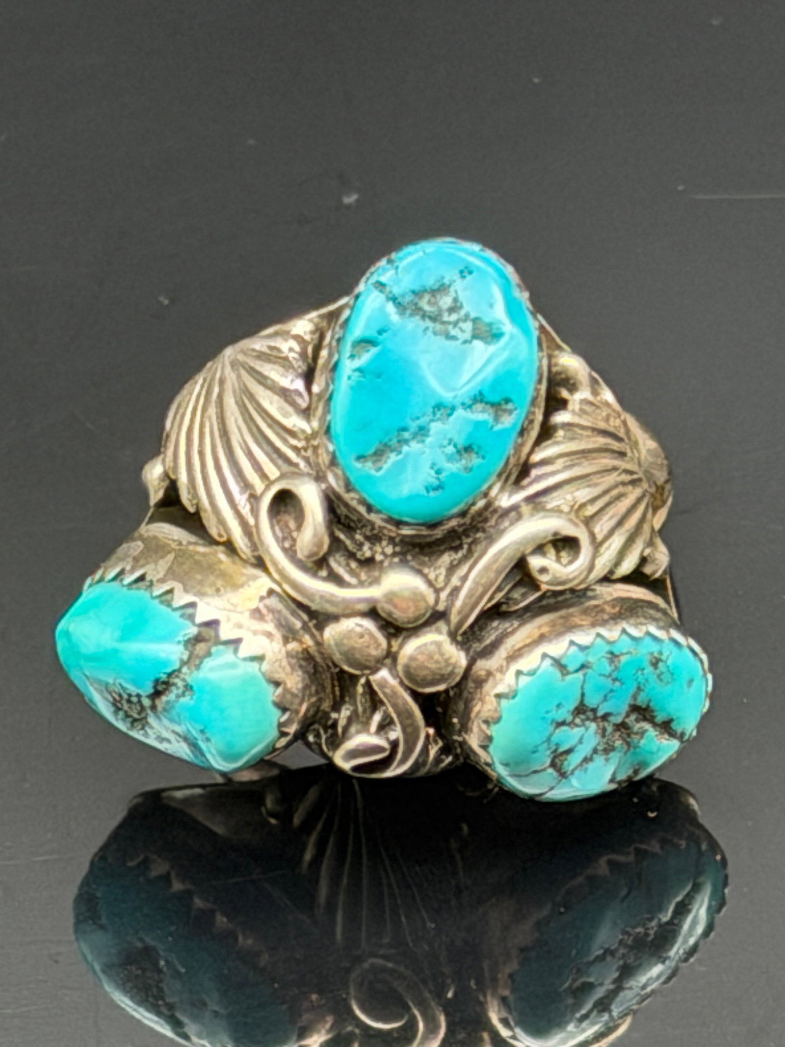 11g-Vintage H Sterling Silver Three Stone Turquoise Cluster Ring: Vintage sterling silver ring featuring three natural turquoise cabochons accented by hand-crafted leaf, scroll, and beadwork details. The stones are set in serrated bezels and display attractive natur