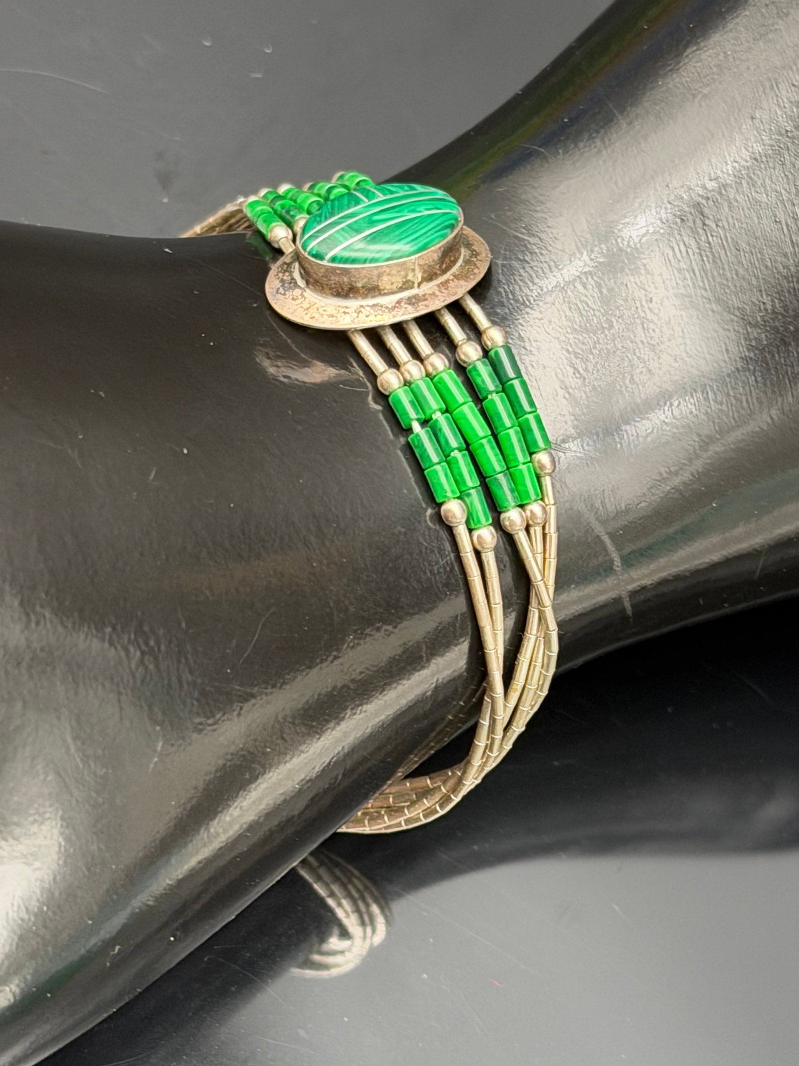 6g-Vintage Sterling Silver Liquid Silver Malachite Bracelet: Vintage sterling silver bracelet featuring multiple strands of delicate liquid silver tube beads centered by an oval malachite cabochon. The vibrant green malachite stone displays attractive natural b