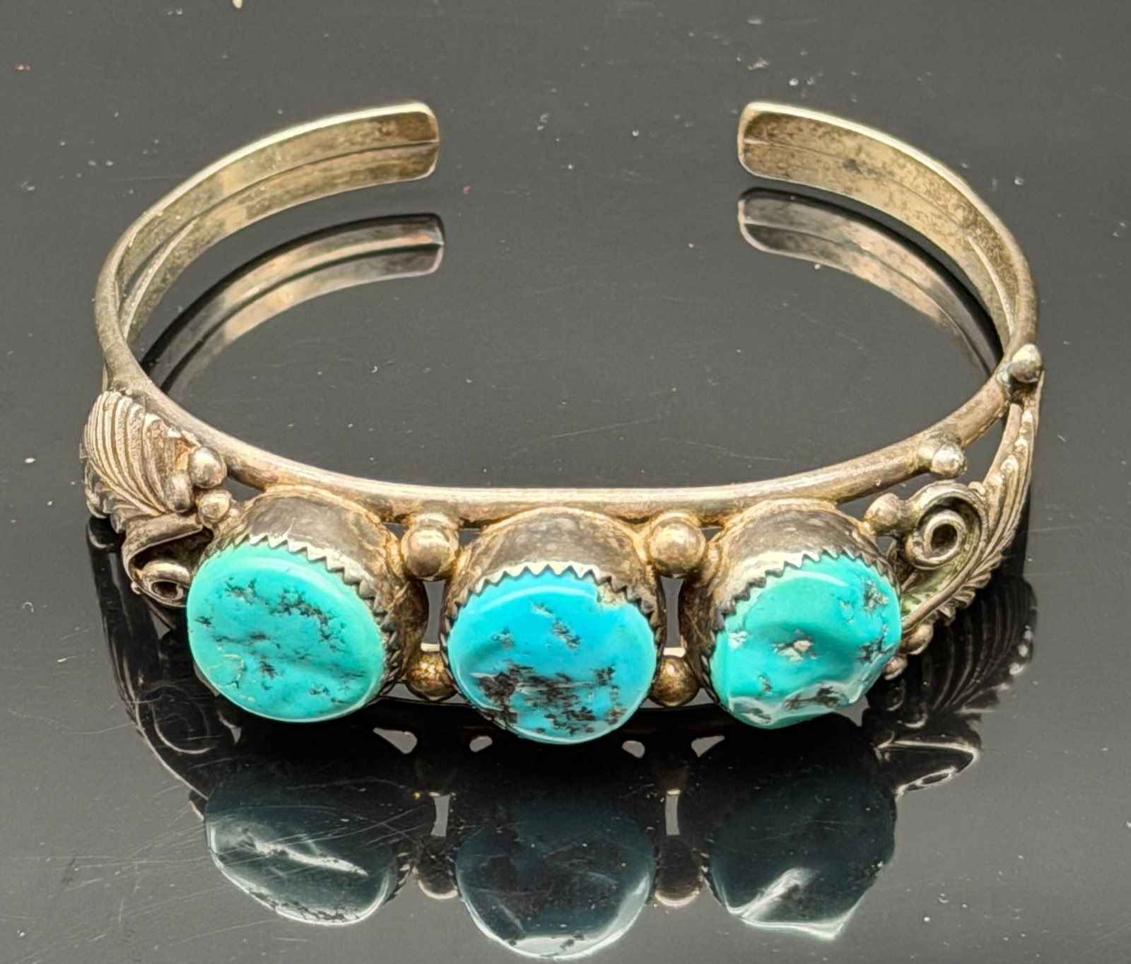 22g-Vintage Native American Sterling Silver Three Stone Turquoise Cuff Bracelet: Beautiful vintage Native American sterling silver cuff bracelet featuring three natural turquoise cabochons in serrated bezel settings. Handcrafted with traditional silverwork including bead accents a