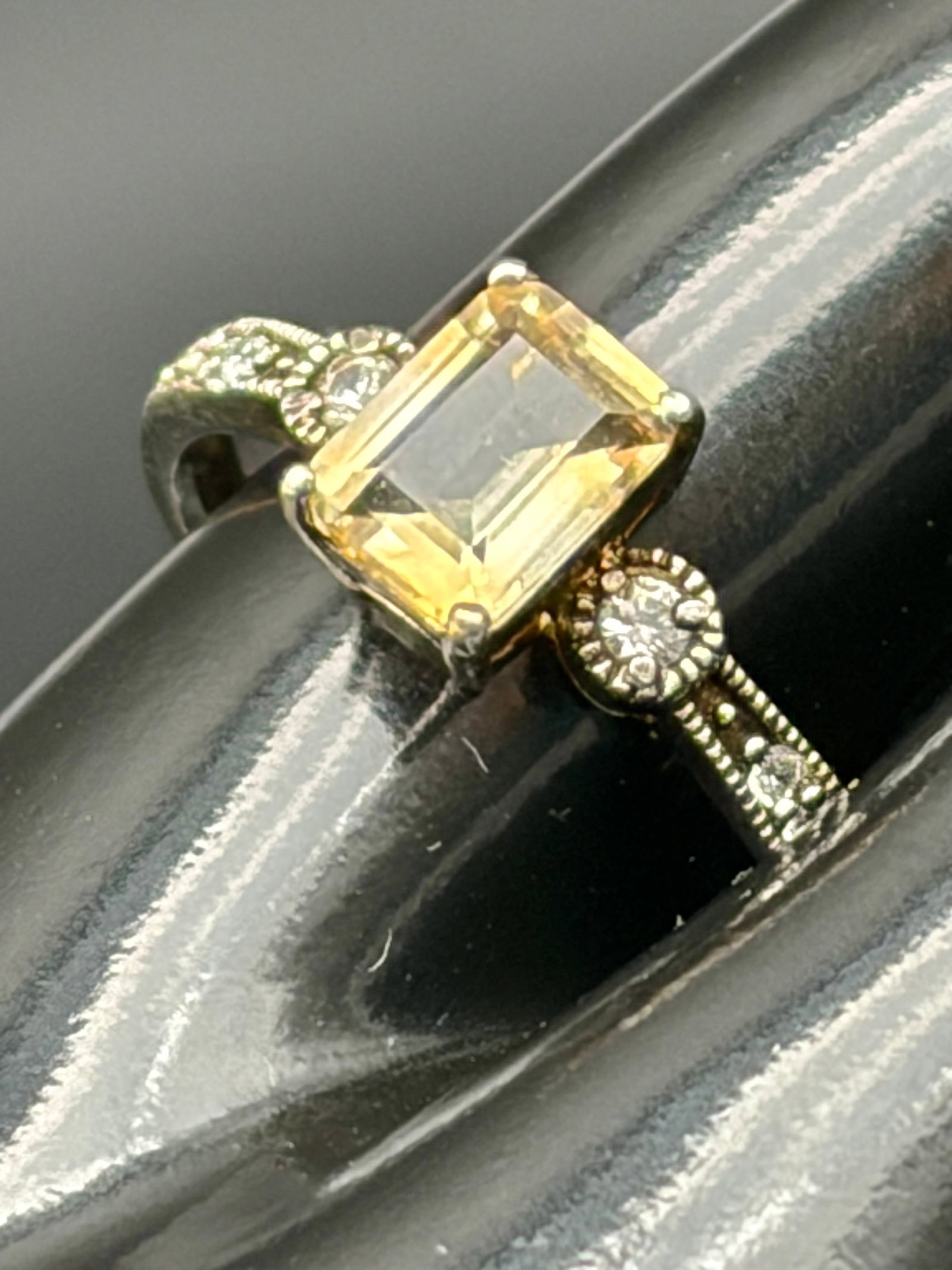 3.3g 925 Silver Citrine CZ Solitaire Ring: Sterling silver ring featuring an emerald-cut citrine-colored center stone accented by sparkling clear CZ side stones and decorative beaded detailing along the band. Weighs 3.3 grams. Elegant and vers