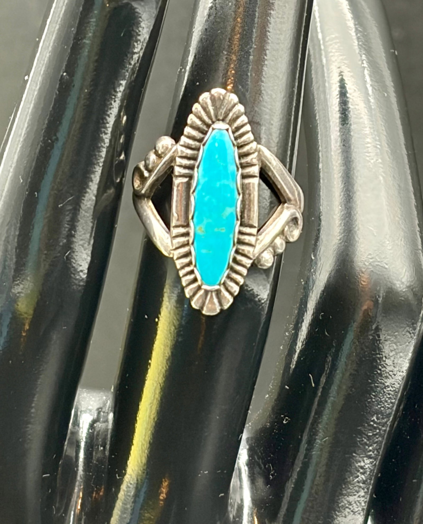 4.4g Sterling Silver Turquoise Ring Southwestern: Sterling silver Southwestern-style ring featuring a vibrant marquise-cut turquoise stone in a decorative bezel setting. Weighs 4.4 grams. Classic Native American-inspired design with geometric detaili