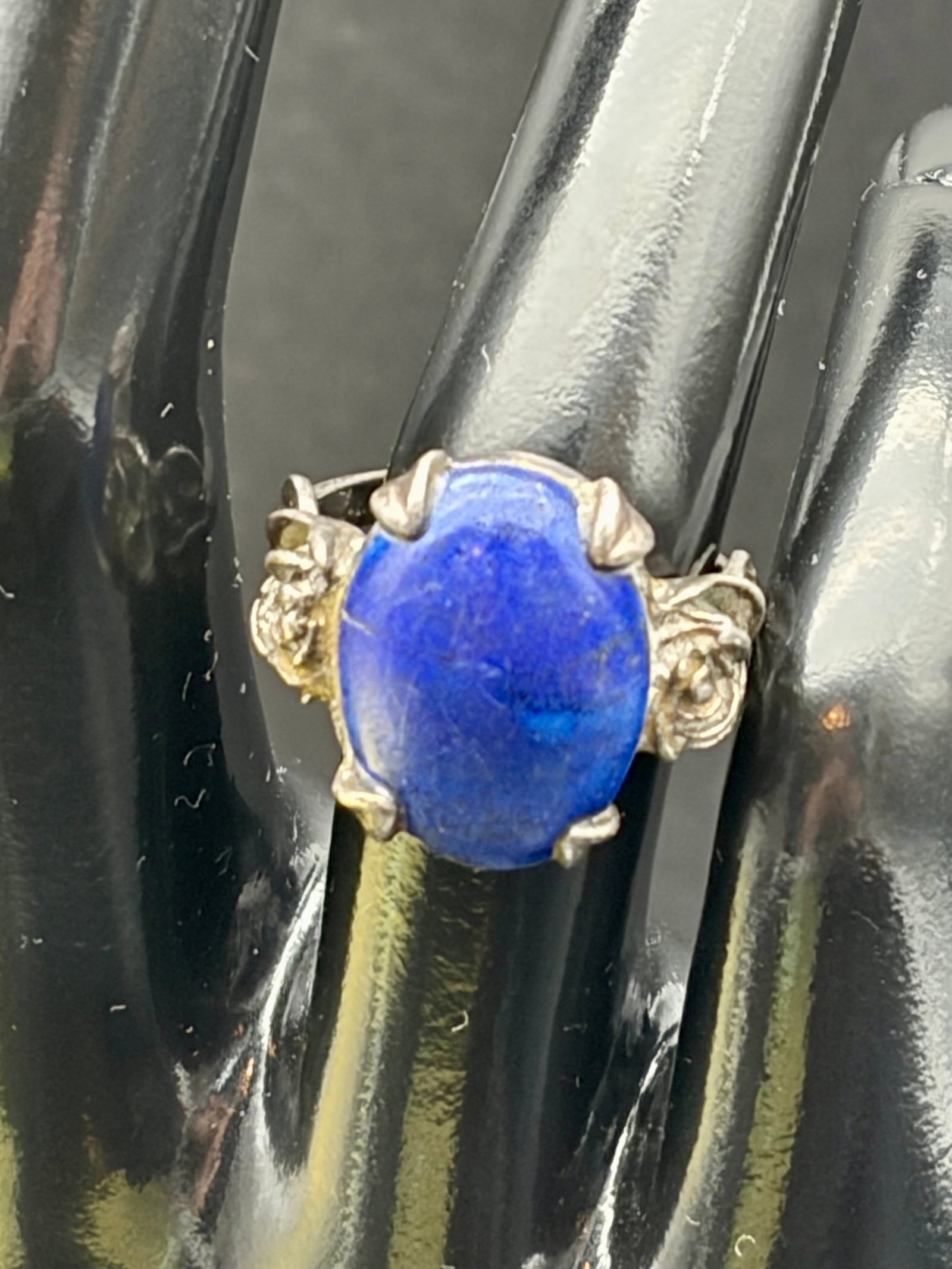 6.2g Sterling Silver Lapis Lazuli Floral Ring Sz 8: Vintage sterling silver ring weighing 6.2g, featuring a polished oval lapis lazuli gemstone in a decorative floral setting. Hallmarked “STERLING.” Rich royal-blue stone with natural color vari