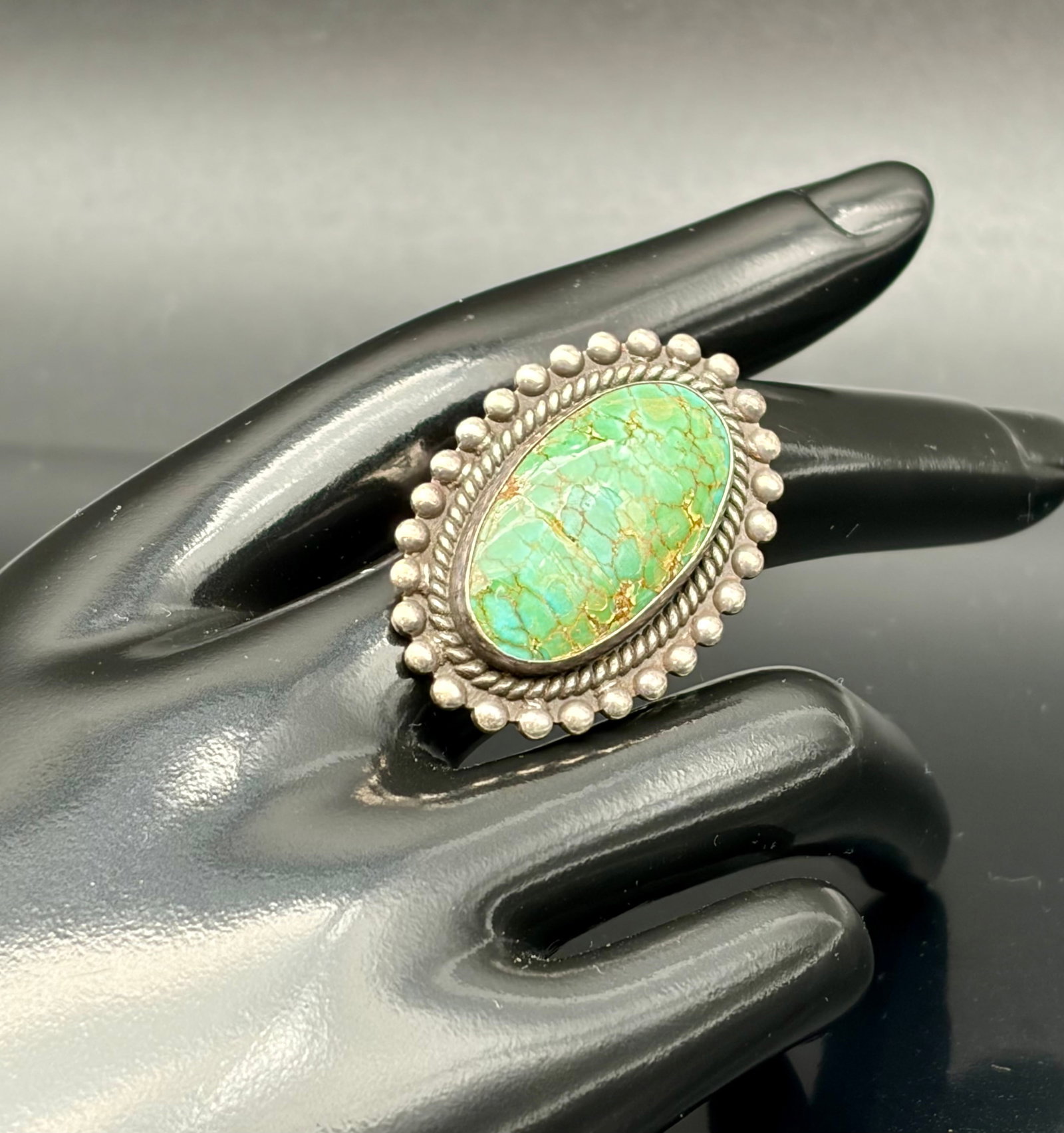 11.8g Vintage Sterling Silver Turquoise Ring NW: Beautiful 11.8g sterling silver ring featuring a large oval turquoise stone with natural matrix veining. Crafted in a classic Southwestern/Native American-inspired style with rope and bead border deta