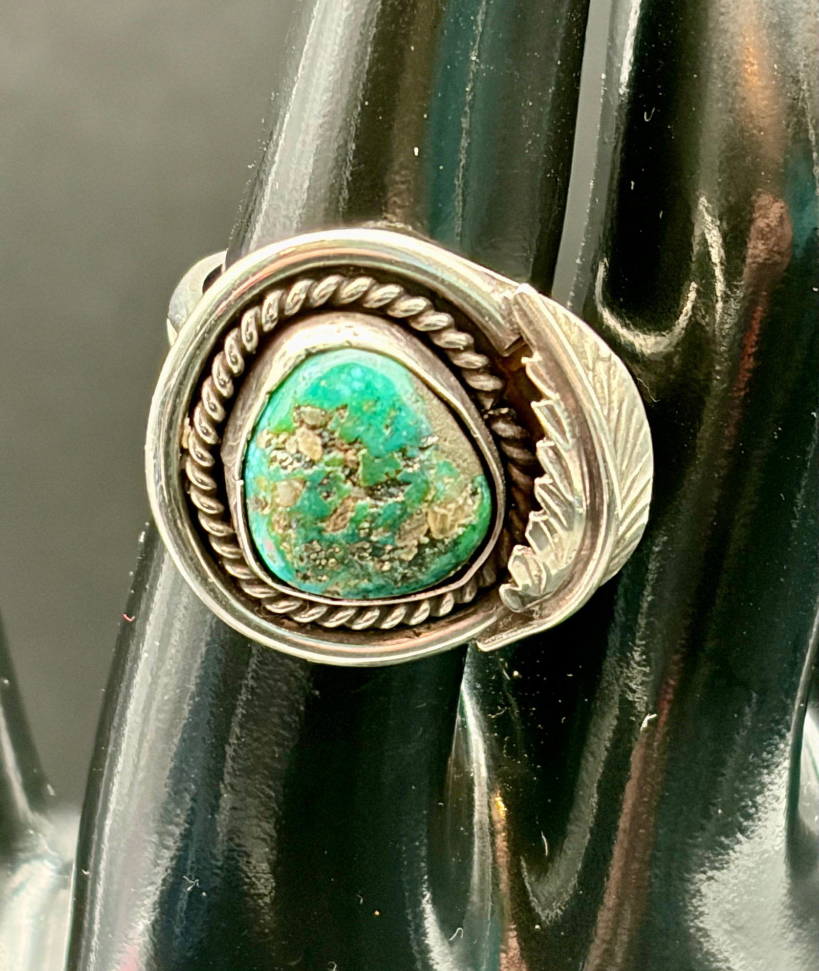 14g Sterling Silver Turquoise Leaf Statement Ring: Beautiful 14g sterling silver ring featuring a natural turquoise stone accented by a twisted rope border and decorative leaf motif. The asymmetrical Southwestern-inspired design showcases earthy blue-
