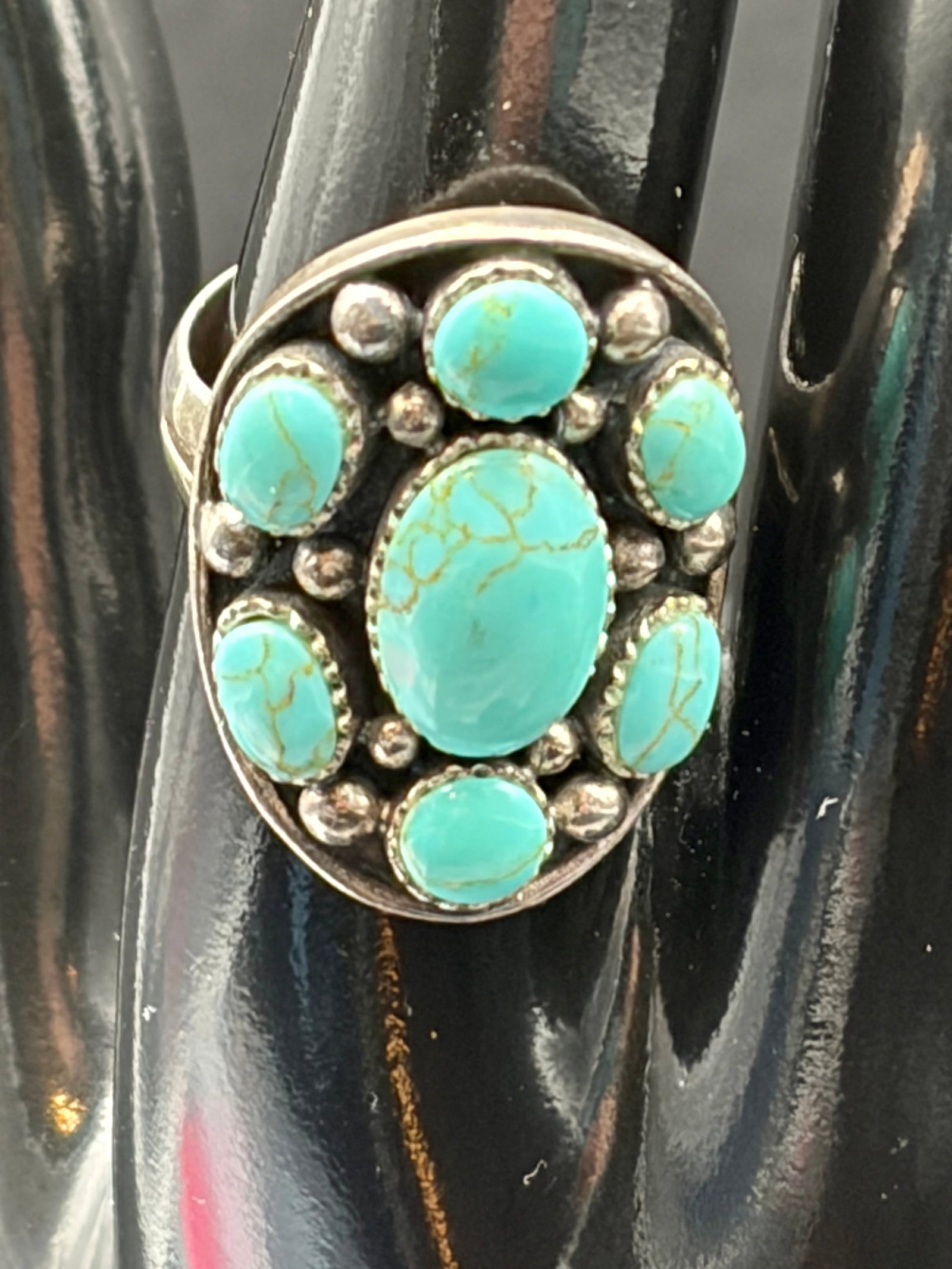 10.5g Sterling Silver Turquoise Cluster Ring 925: Bold 10.5g sterling silver ring marked 925, featuring a striking turquoise-style cluster design with seven cabochon stones set in an elongated oval face. The vintage Southwestern-inspired setting show