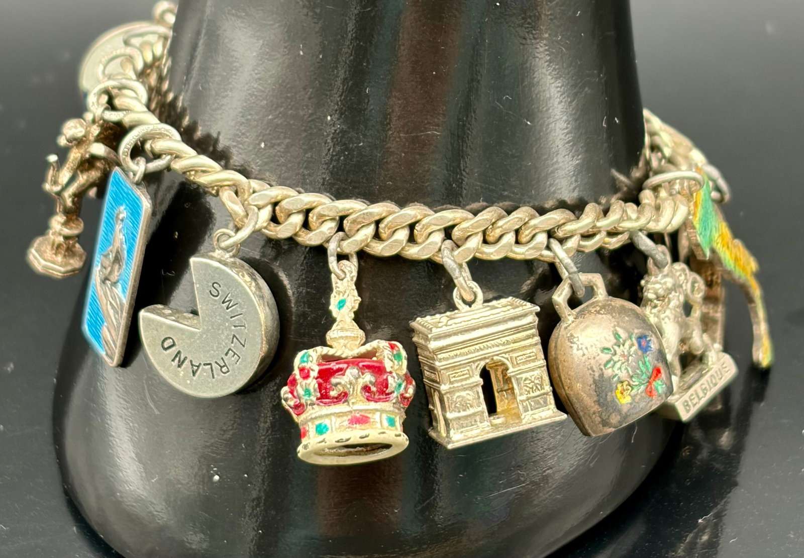 50.1g Vintage European Travel Charm Bracelet Souvenir Bracelet: Vintage European souvenir charm bracelet featuring 14 travel-themed charms including Paris Arc de Triomphe, Big Ben London, Stockholm, Switzerland, Belgium, Dutch clogs, crown, bell, and enamel travel