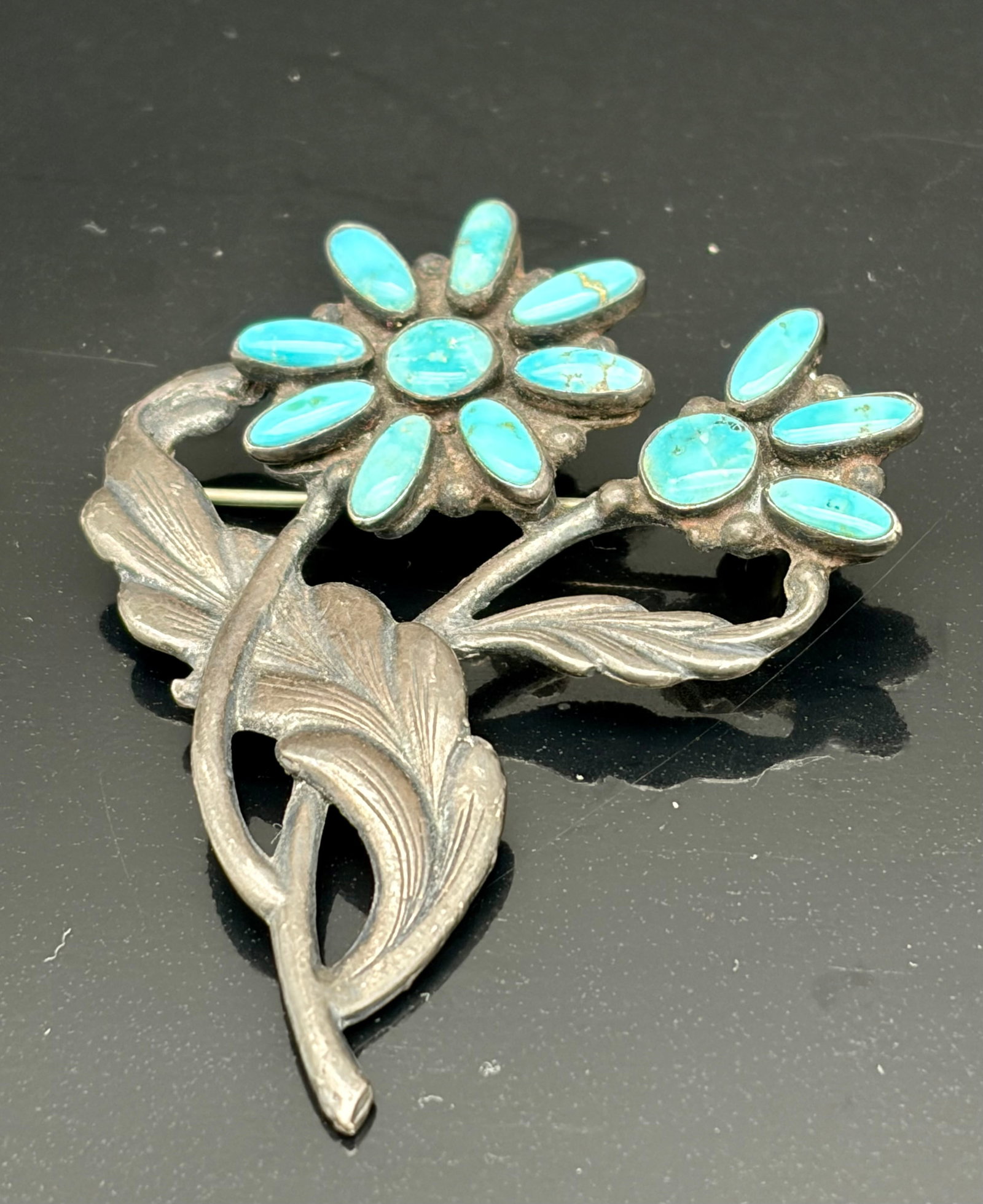 15.0g Vintage Turquoise Flower Brooch Sterling Silver: Beautiful vintage sterling silver floral brooch featuring two flower blossoms set with vibrant turquoise cabochons and flowing leaf details. A classic Southwestern-inspired design with natural turquoi
