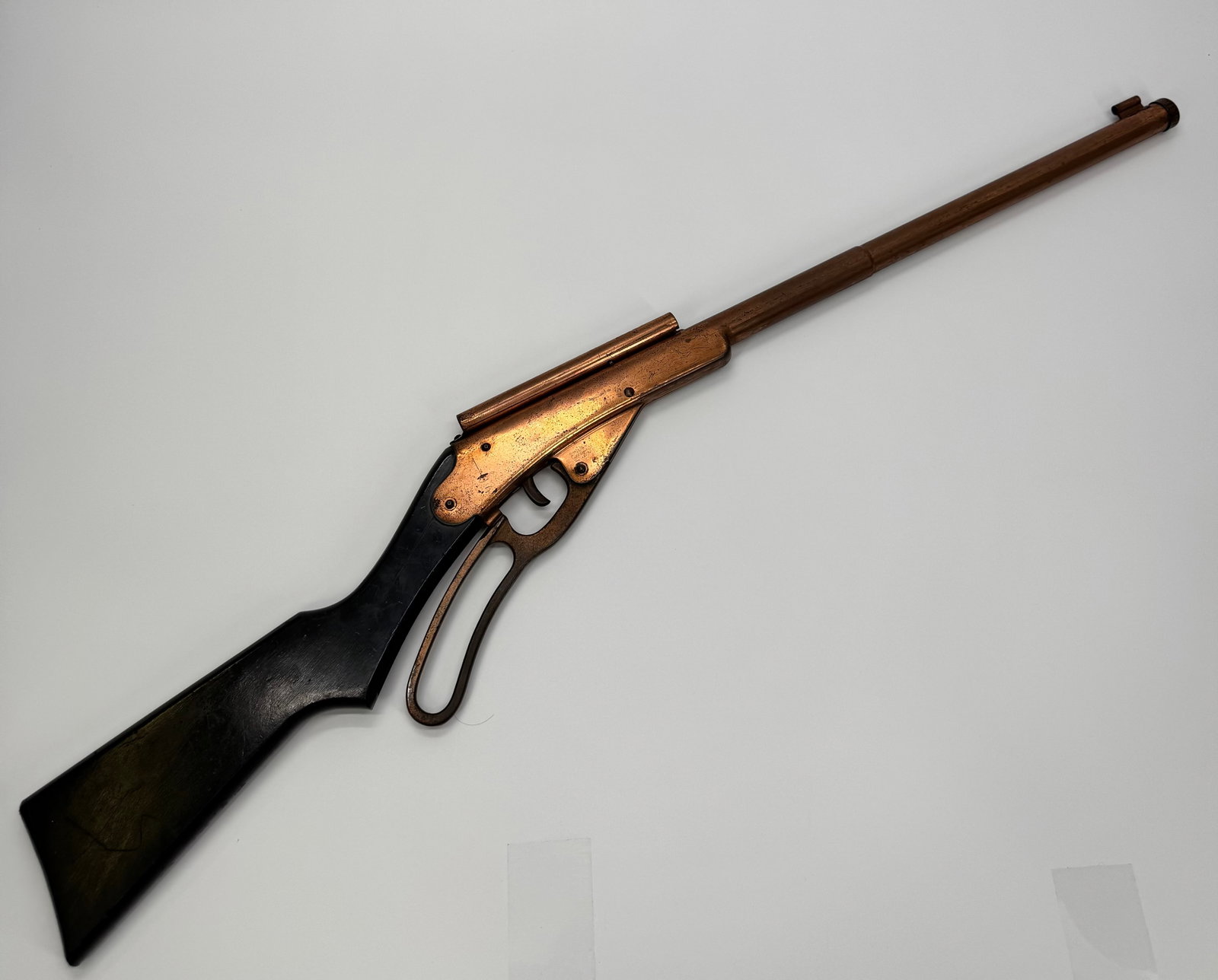 Vintage Daisy Golden Eagle Lever Action BB Gun: Vintage Daisy Golden Eagle lever-action BB gun featuring the original black-painted stock with Golden Eagle anniversary decal marked “1886–1936.” Copper-tone receiver, lever-action cocking m