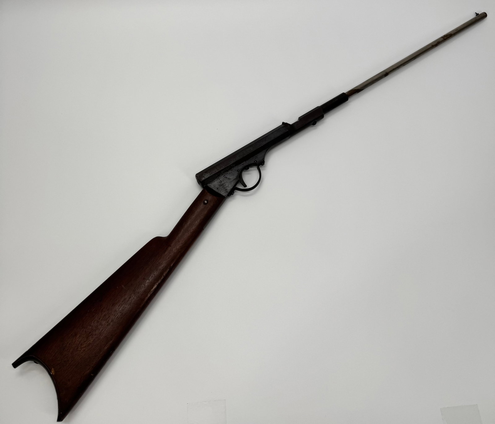 Vintage Single Shot Air Rifle BB Gun: Vintage single-shot air rifle featuring an octagonal metal receiver, wood stock, and long barrel. Constructed with a simple break-cock or plunger-style action typical of early youth air guns. Exhibits