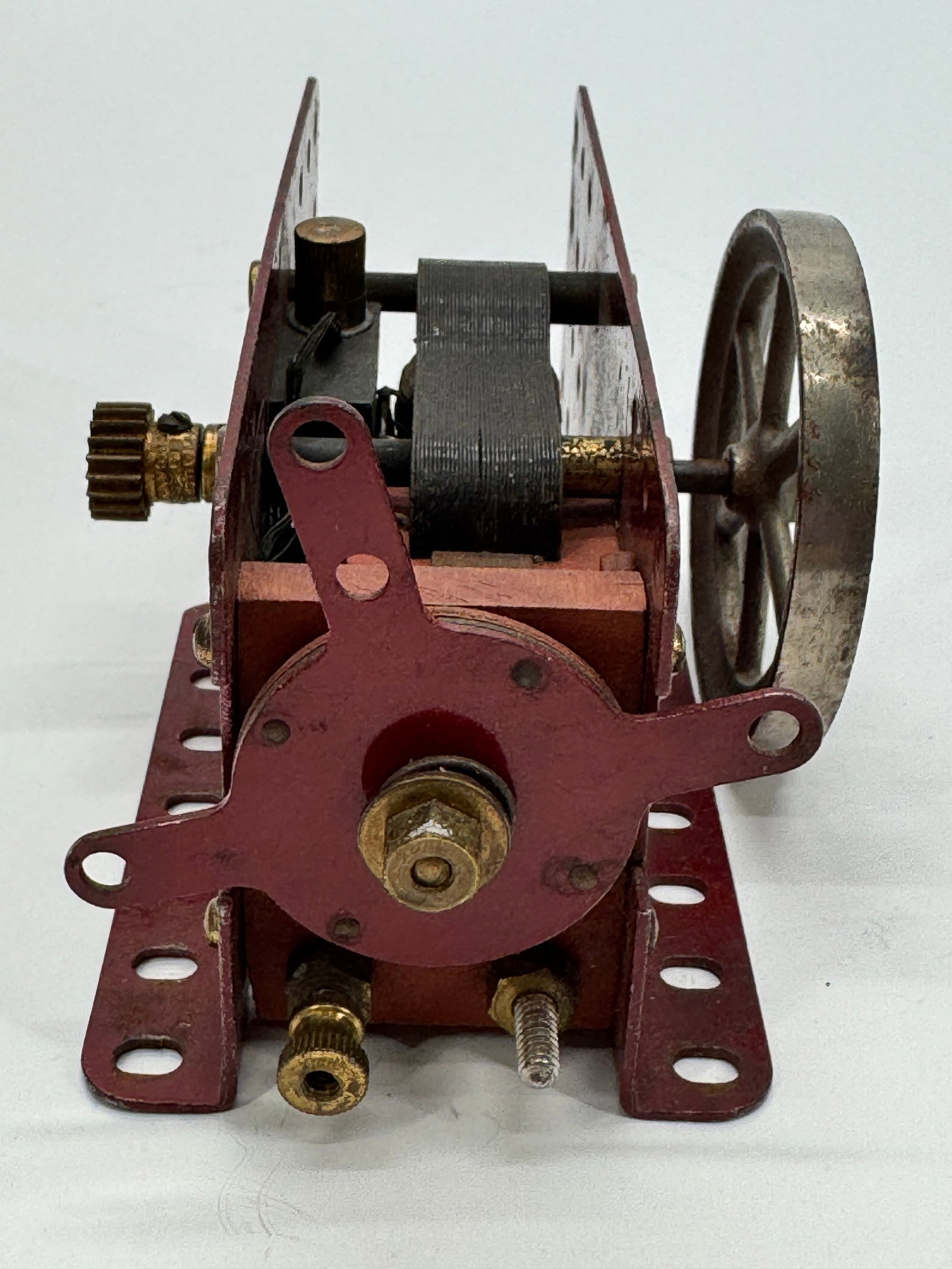 Vintage Meccano Electric Motor Model Made in England: Vintage Meccano Ltd. electric motor assembly mounted on a red painted perforated steel frame with brass hardware and flywheel. Manufactured in Liverpool, England, this early educational and demonstrat