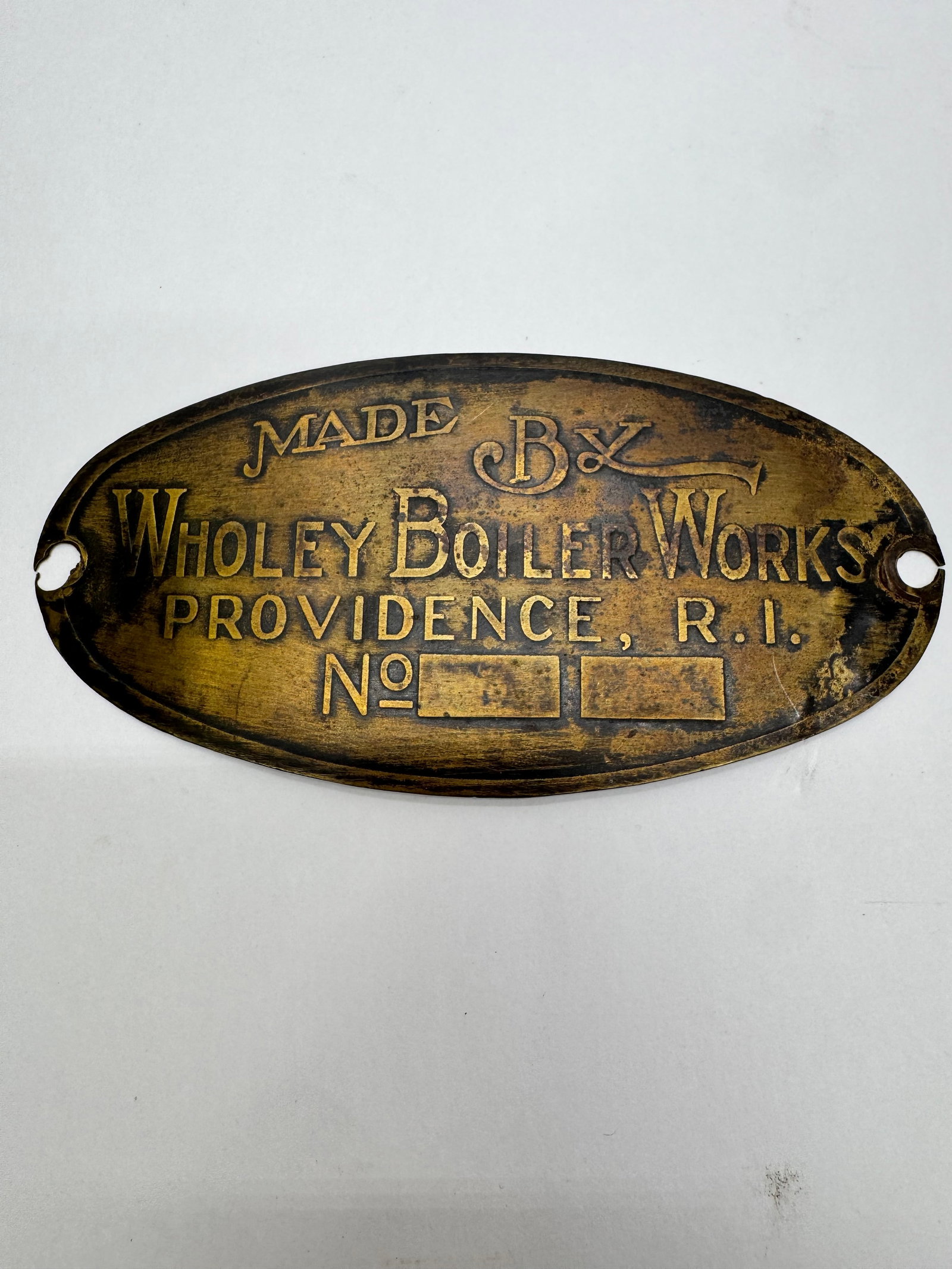 Antique Wholey Boiler Works Brass Boiler Plate: Antique oval brass maker’s plate marked “Made By Wholey Boiler Works, Providence, R.I.” Originally mounted to a steam boiler or industrial heating apparatus. Features raised lettering and de
