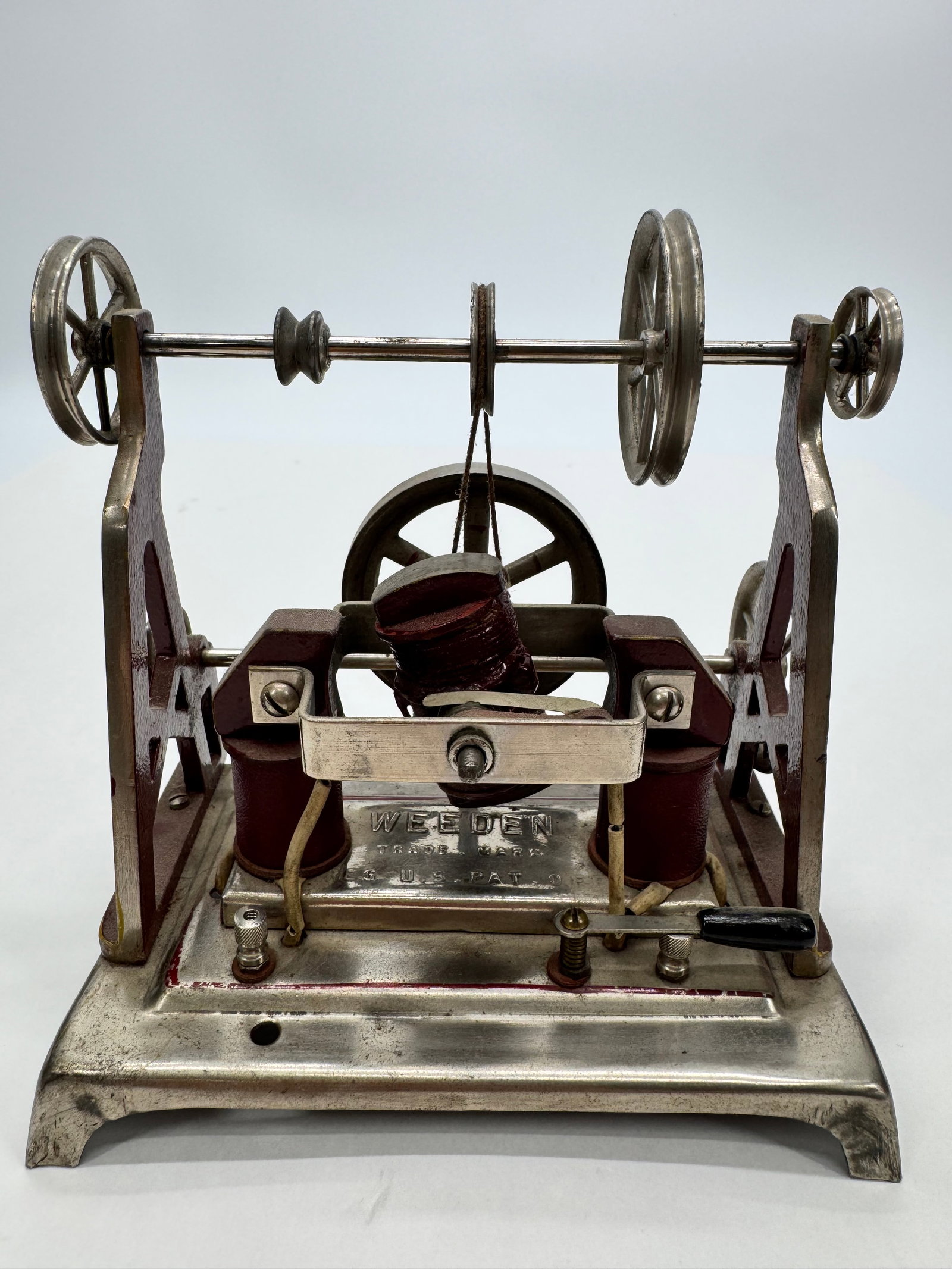 Antique Weeden Electrical Demonstration Apparatus: Antique Weeden electrical demonstration apparatus featuring cast metal construction, dual coils, belt-driven pulleys, and adjustable electrical components mounted on a nickel-finished base. Marked “