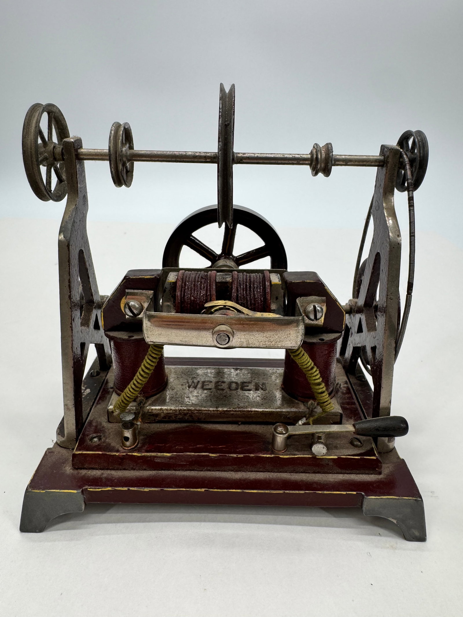 Antique Weeden Dynamo Demonstration Machine: Antique Weeden electrical demonstration machine featuring cast iron supports, dual field coils, commutator assembly, pulley-driven shaft, and original painted base. Marked “WEEDEN” on the cast