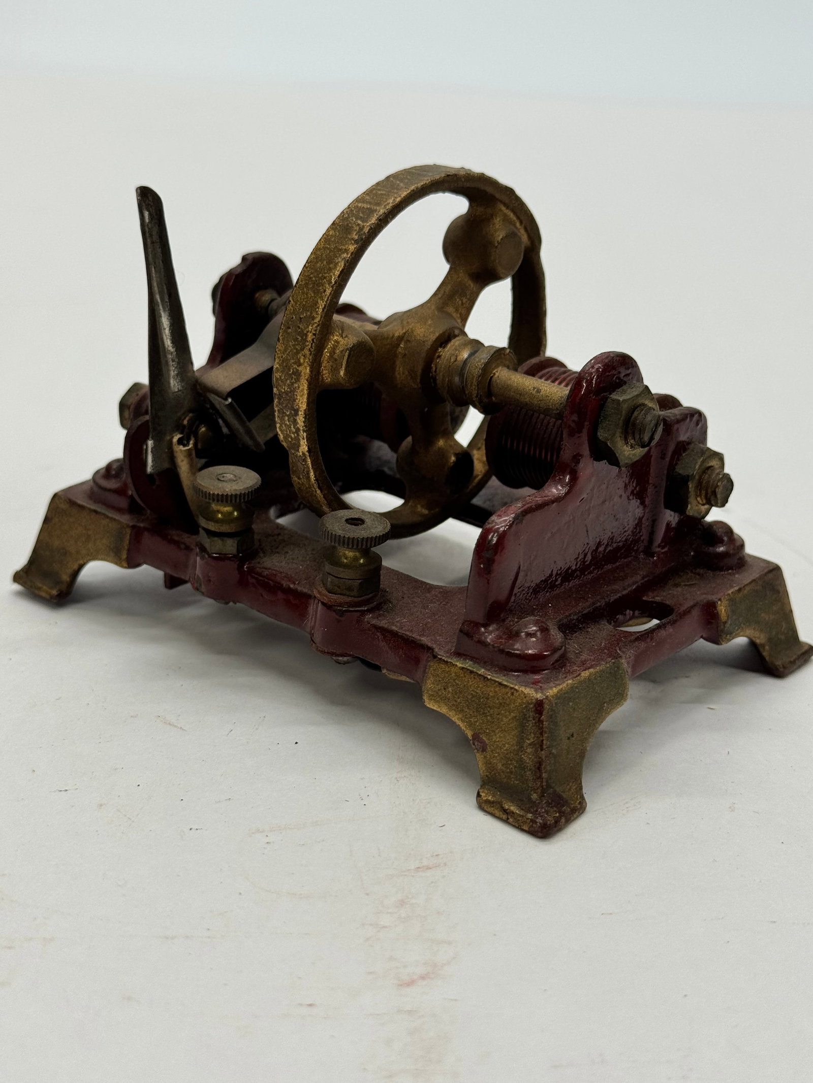 Antique Weeden Electromagnetic Motor Demonstrator: Antique Weeden electromagnetic motor or electrical demonstration apparatus featuring a cast iron frame, brass-tone flywheel, twin copper-wound field coils, and mechanical contact arm. Designed as an e