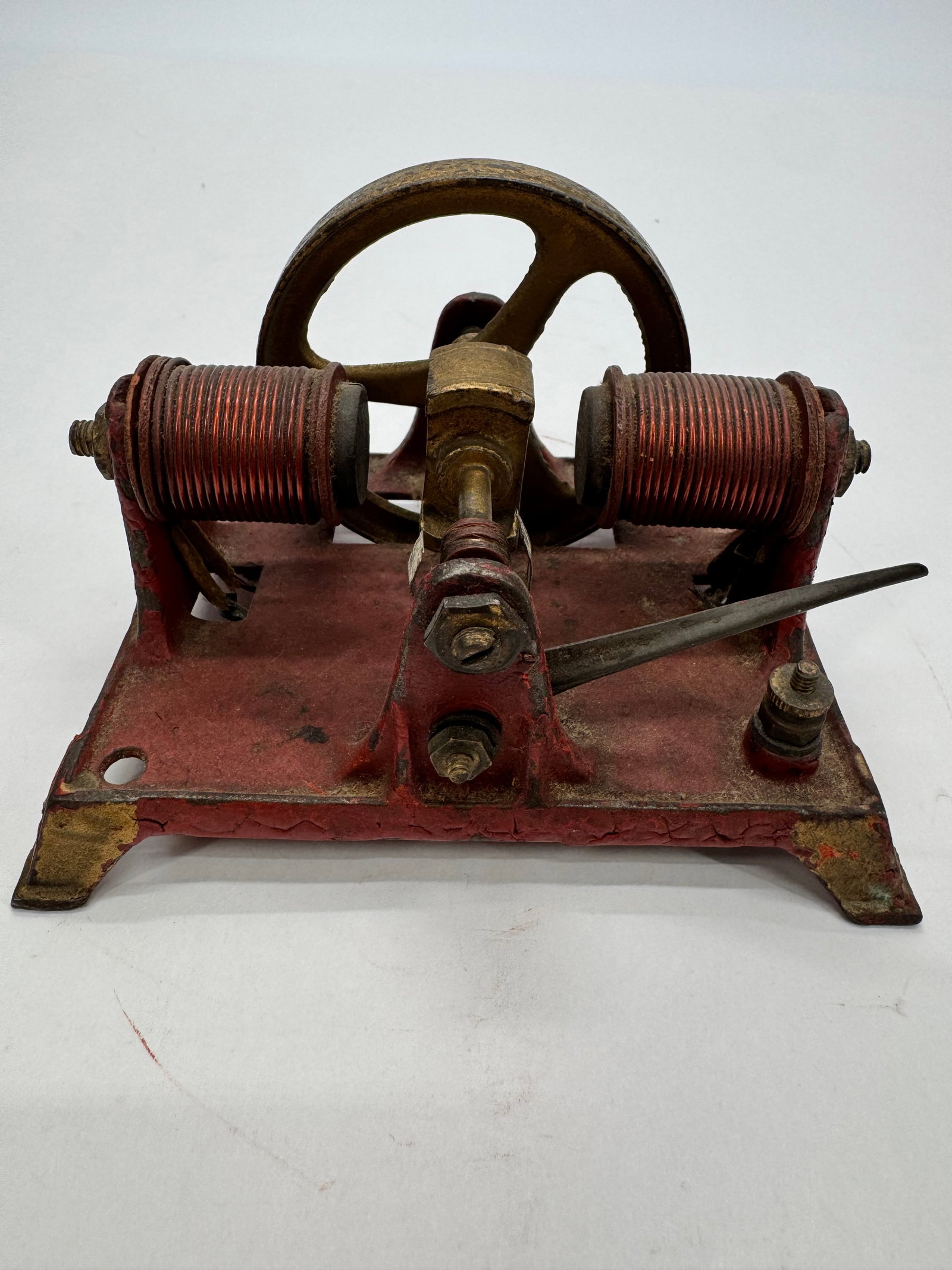 Antique Weeden Electric Motor Demonstrator: Antique early Weeden electric motor or electromagnetic demonstration apparatus featuring a cast iron frame, dual copper-wound field coils, brass-tone flywheel, and mechanical contact arm. Designed as 
