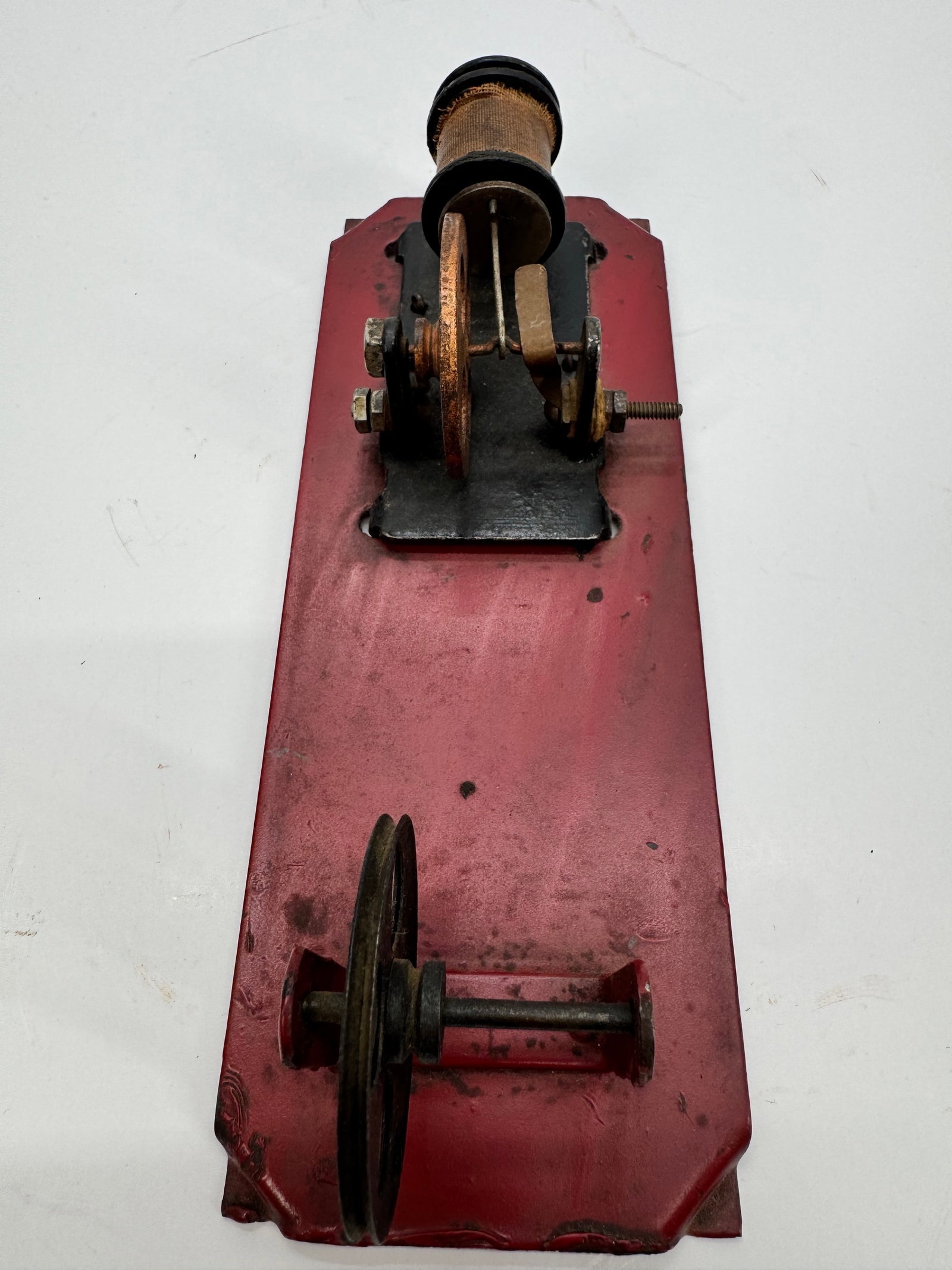 Antique Single-Coil Electromagnetic Motor: Antique electromagnetic demonstration motor featuring a cloth-wrapped field coil, cast iron flywheel, make-and-break contact mechanism, and painted display base. Designed to illustrate the principles 