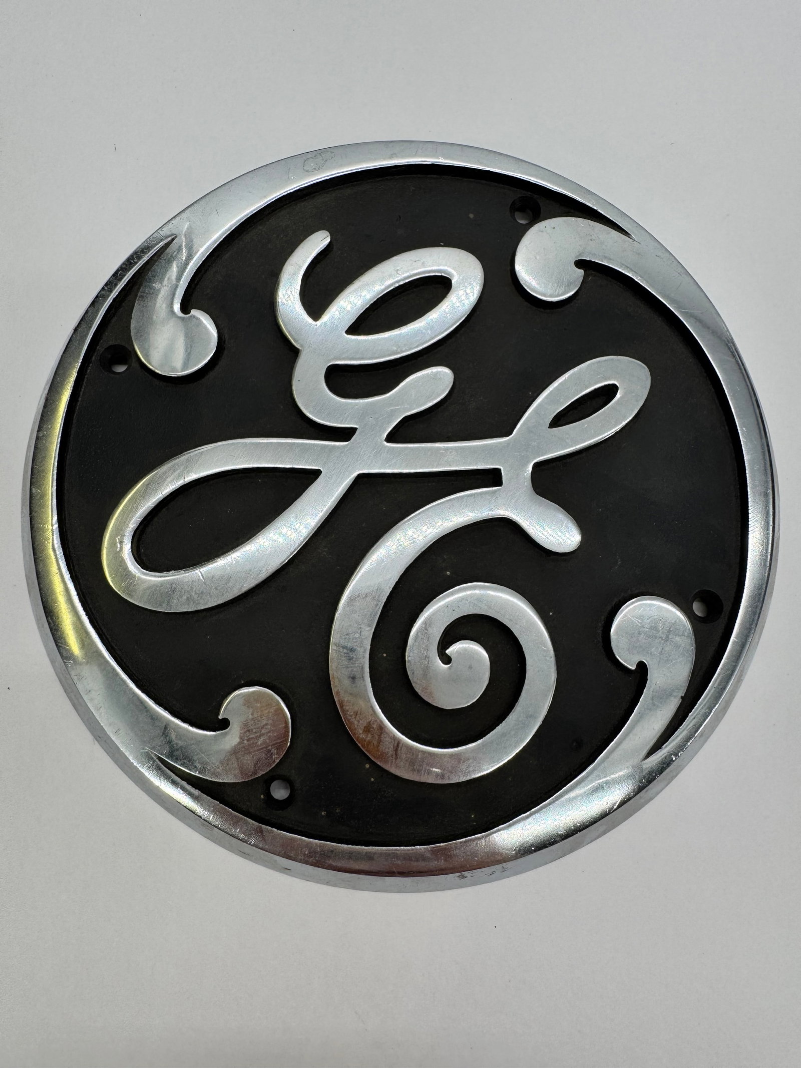 Vintage General Electric GE 6” Cast Aluminum Industrial Logo Emblem Sign: Original General Electric cast aluminum emblem featuring the classic raised GE script logo against a black background. Measures approximately 6 inches in diameter and retains its original industrial f