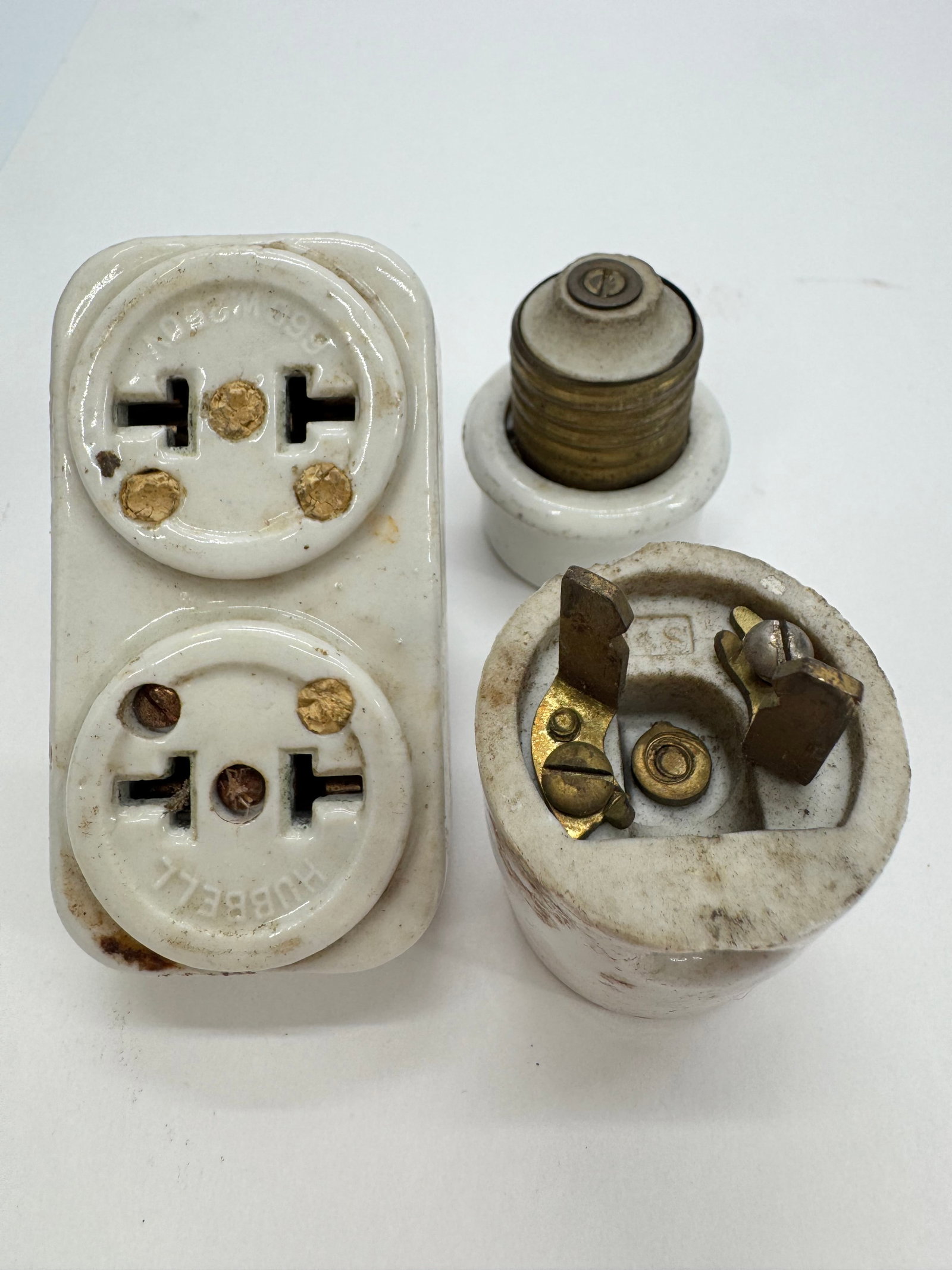 Antique Hubbell Porcelain Electrical Outlet Adapter Plug Lot 6A 250V: Collection of antique Hubbell porcelain electrical fittings dating to the early 20th century. Includes a double receptacle marked 6A 250V, a porcelain screw-base lamp socket adapter, and an early atta