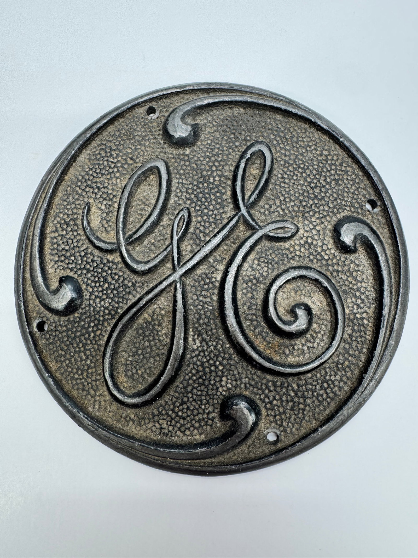 Antique General Electric GE Fan Cage Badge Medallion NP-36006: Original antique General Electric fan cage medallion with raised GE script and textured background. Reverse stamped NP-36006. Cast metal construction with age-related wear and patina. Removed from an 