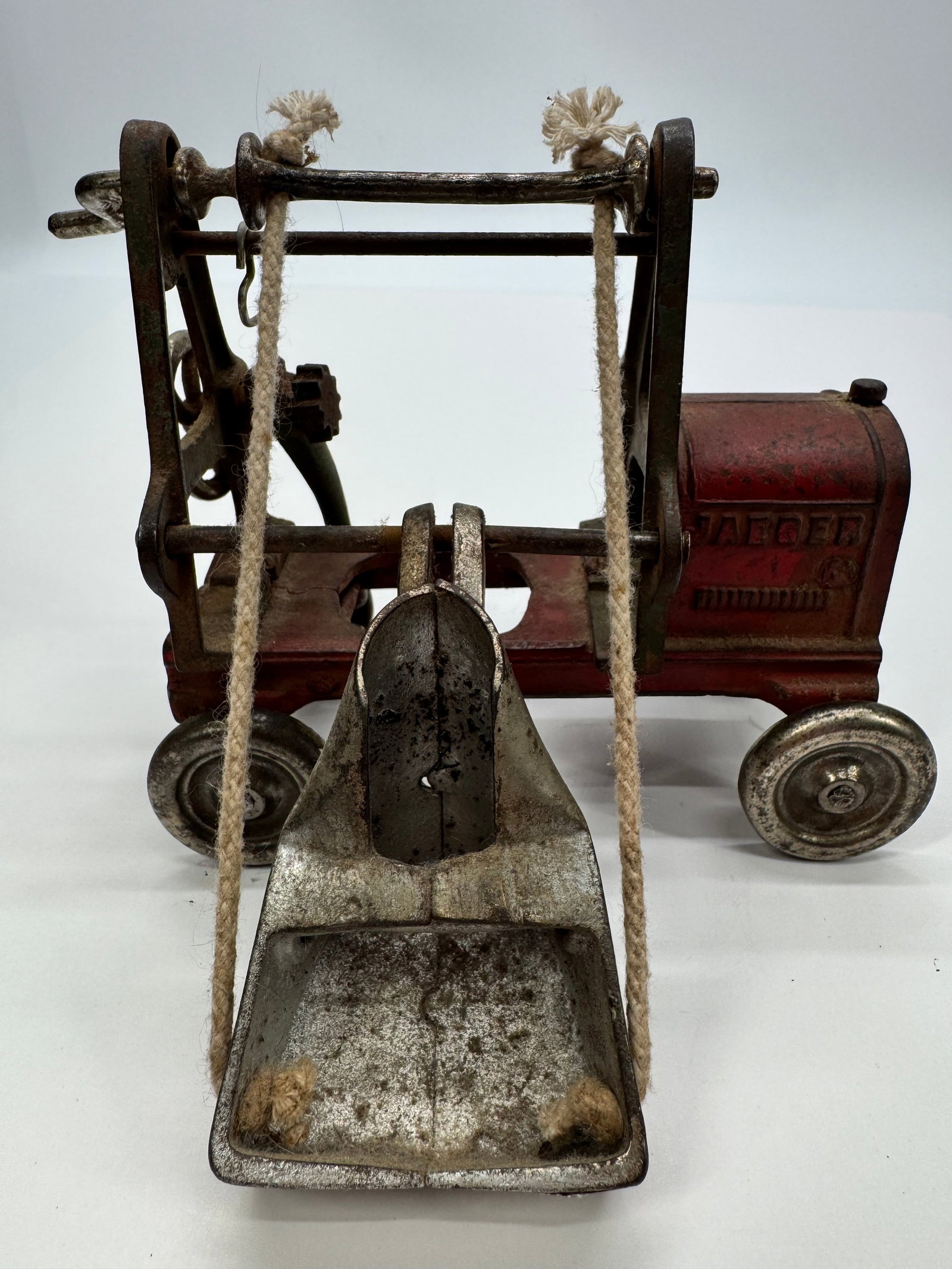 Antique Jaeger Cast Iron Toy Grain Elevator Conveyor Columbus Ohio: Antique Jaeger Manufacturing Co. cast iron toy grain elevator featuring original red-painted cast body, steel wheels, hand crank, rope lift mechanism, and metal scoop. Manufactured in Columbus, Ohio i