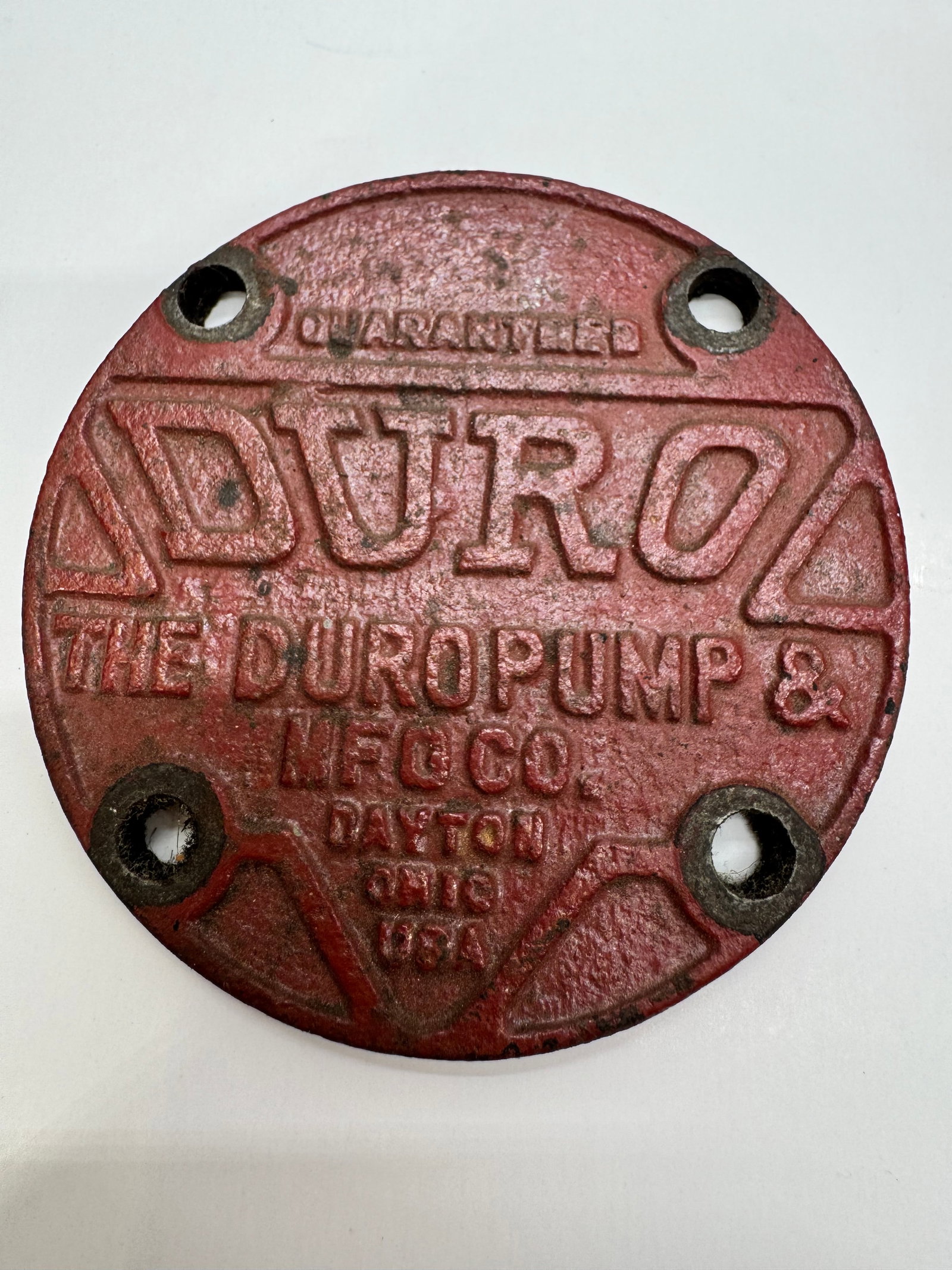 Antique Duro Pump & Mfg Co Cast Iron Nameplate Dayton Ohio: Original cast iron nameplate from The Duro Pump & Manufacturing Company of Dayton, Ohio. Features raised lettering with traces of original red paint and four mounting holes. Displays age-related wear,