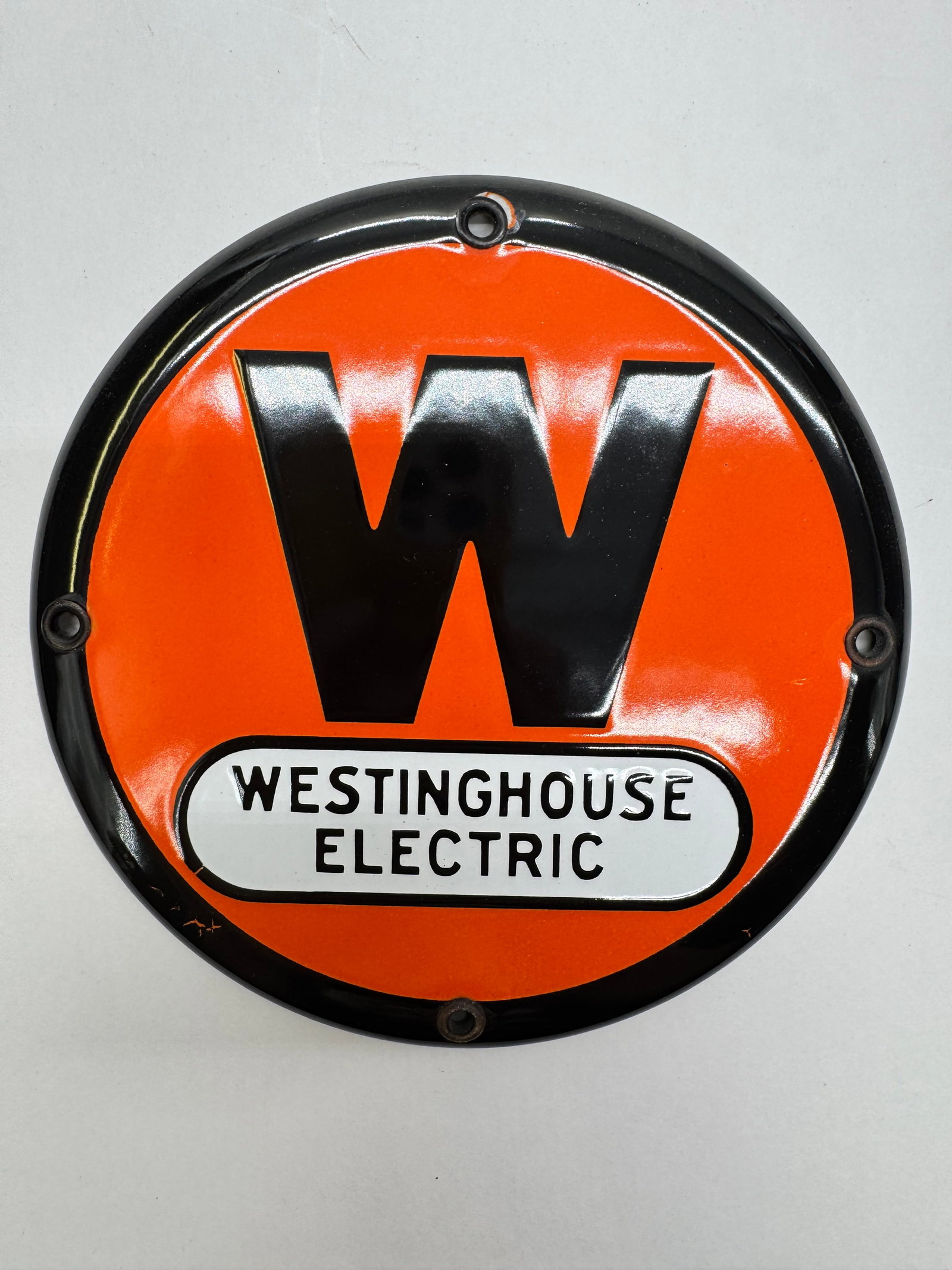 Vintage Westinghouse Electric 6” Porcelain Enamel Sign: Vintage Westinghouse Electric porcelain enamel advertising sign featuring the iconic orange-and-black "W" logo and raised white Westinghouse Electric panel.Approximately 6 inches in diameter with blac