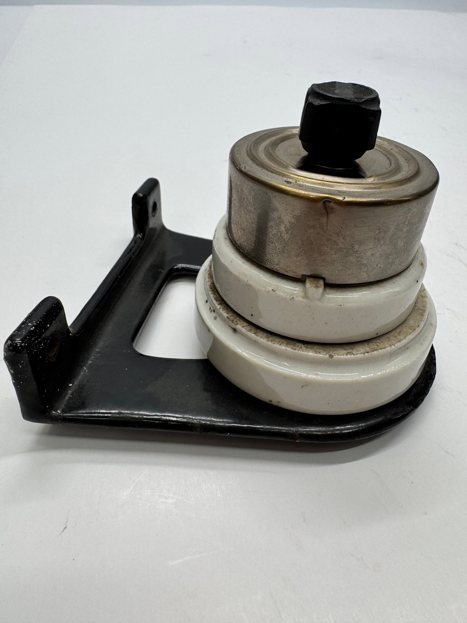 Antique Perkins 1912 Porcelain Rotary Twist Light Switch: Early 20th-century Perkins Electric rotary twist switch featuring a black cast-metal mounting bracket and white porcelain insulator stack. Made in the USA and rated 5A 125V. A desirable piece of antiq