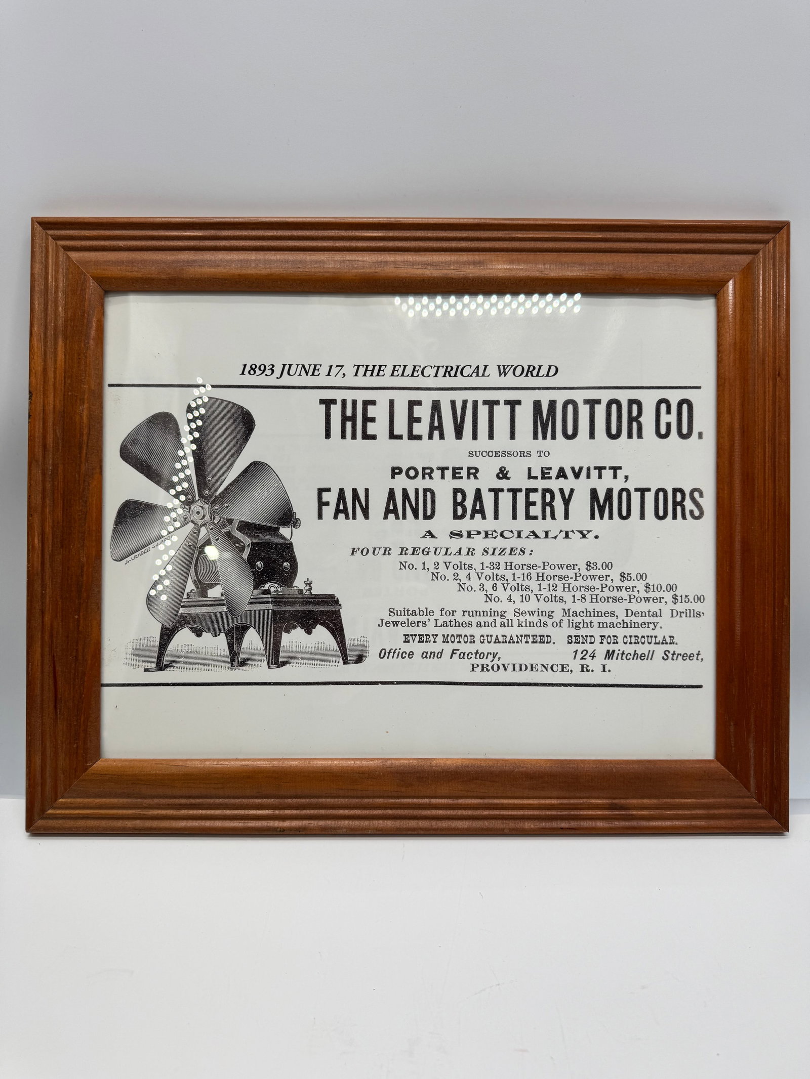 Framed Leavitt Motor Co. 1893 Electrical World Advertisement Reproduction: Framed reproduction of an 1893 Electrical World advertisement for The Leavitt Motor Co., Providence, Rhode Island. Features an illustration of an early electric fan and battery motor with period prici