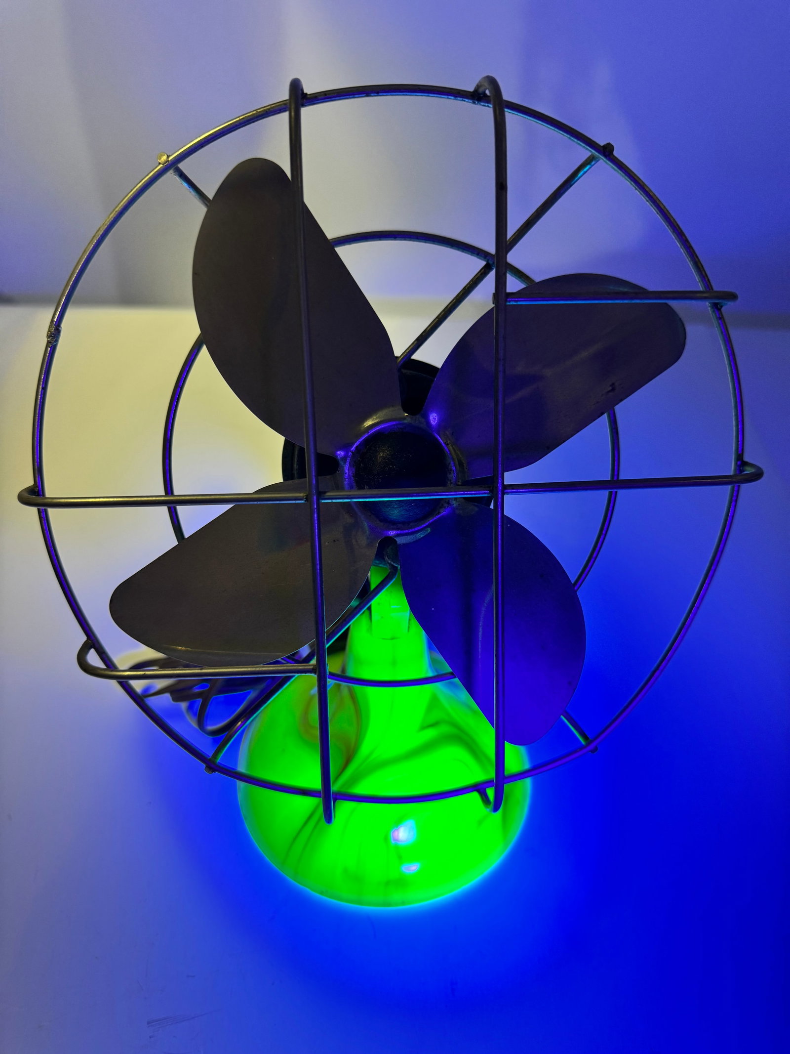 Vintage Electric Fan w/ Uranium Glass Base UV Reactive: Vintage electric desk fan featuring a striking uranium (vaseline) glass base that glows bright green under UV light. Includes a four-blade metal fan, wire safety cage, and original power cord. A uniqu