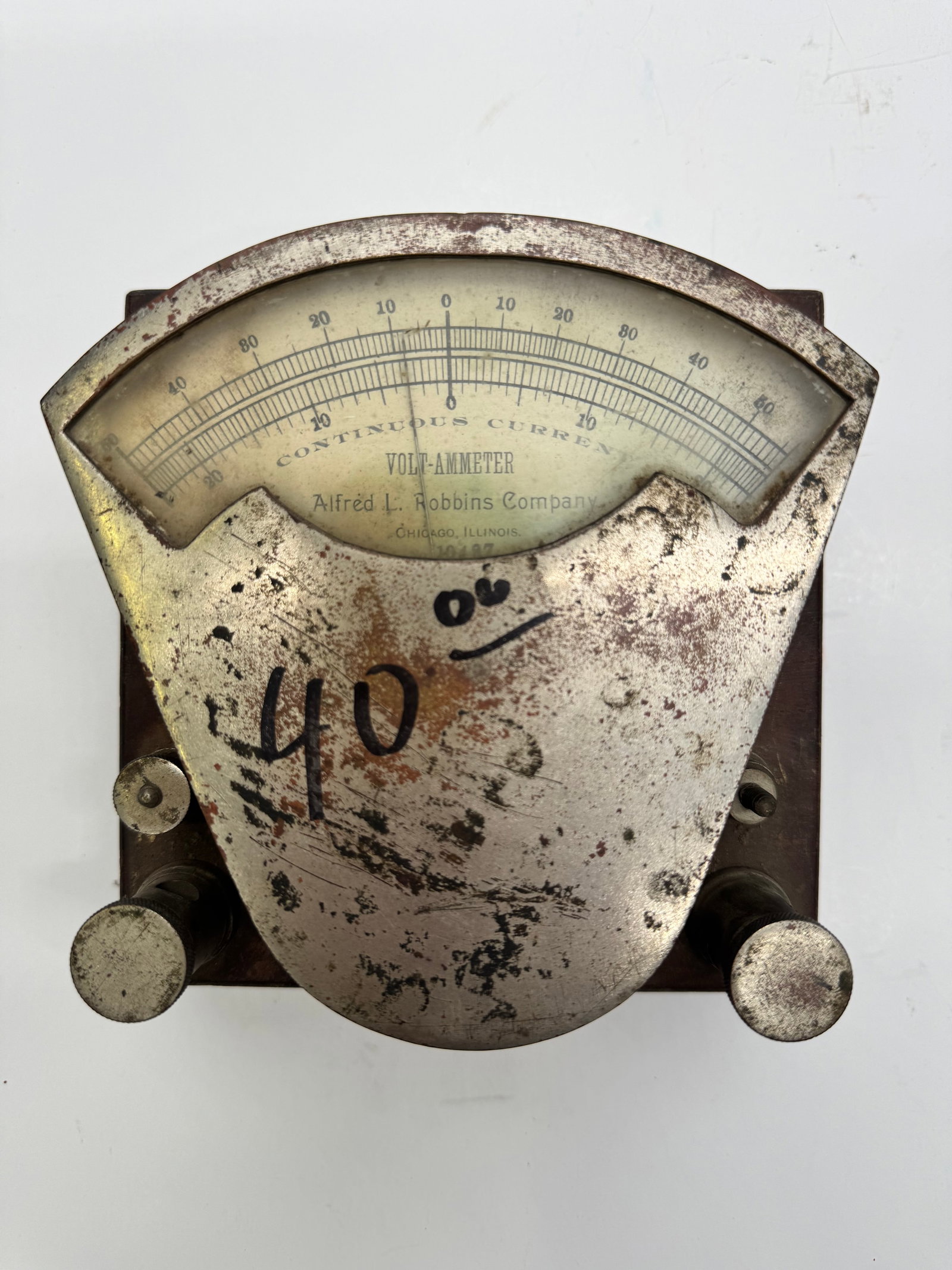 Antique Alfréd L. Robbins Volt-Ammeter Continuous Current Meter: Antique Alfréd L. Robbins Company Volt-Ammeter for measuring continuous (DC) current. Features an arc-shaped analog gauge with a nickel-plated face mounted on a wooden base. An early 20th-century sci