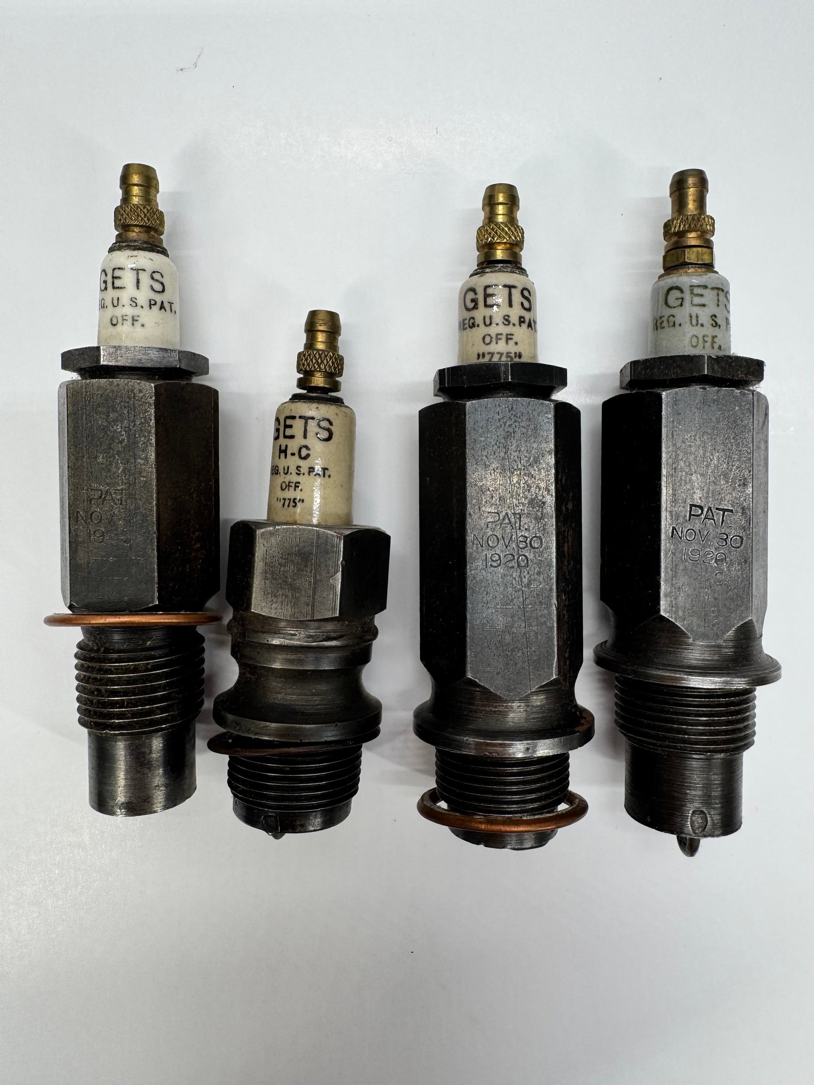 Lot of 4 Antique Gets H-C Spark Plugs Pat. Nov. 30 1920: Lot of four antique Gets porcelain spark plugs, including Gets H-C examples, marked “REG. U.S. PAT. OFF.” and stamped “PAT. NOV. 30, 1920.” These early automotive ignition components f