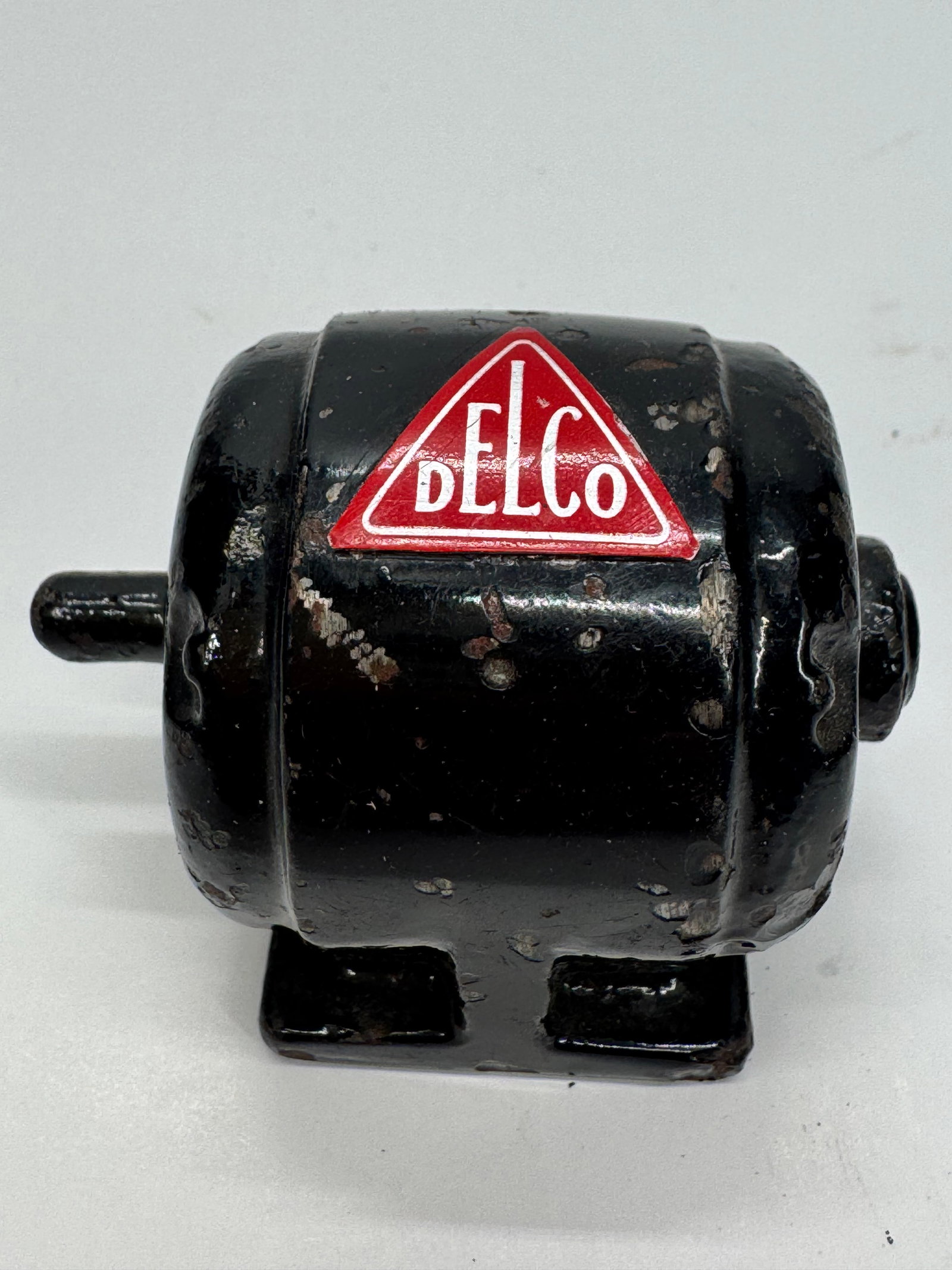 Vintage DELCO Electric Motor Paperweight: Vintage DELCO cast metal motor paperweight featuring the iconic red DELCO triangle logo. Designed as a miniature electric motor, this promotional advertising piece was produced for Delco and used as a