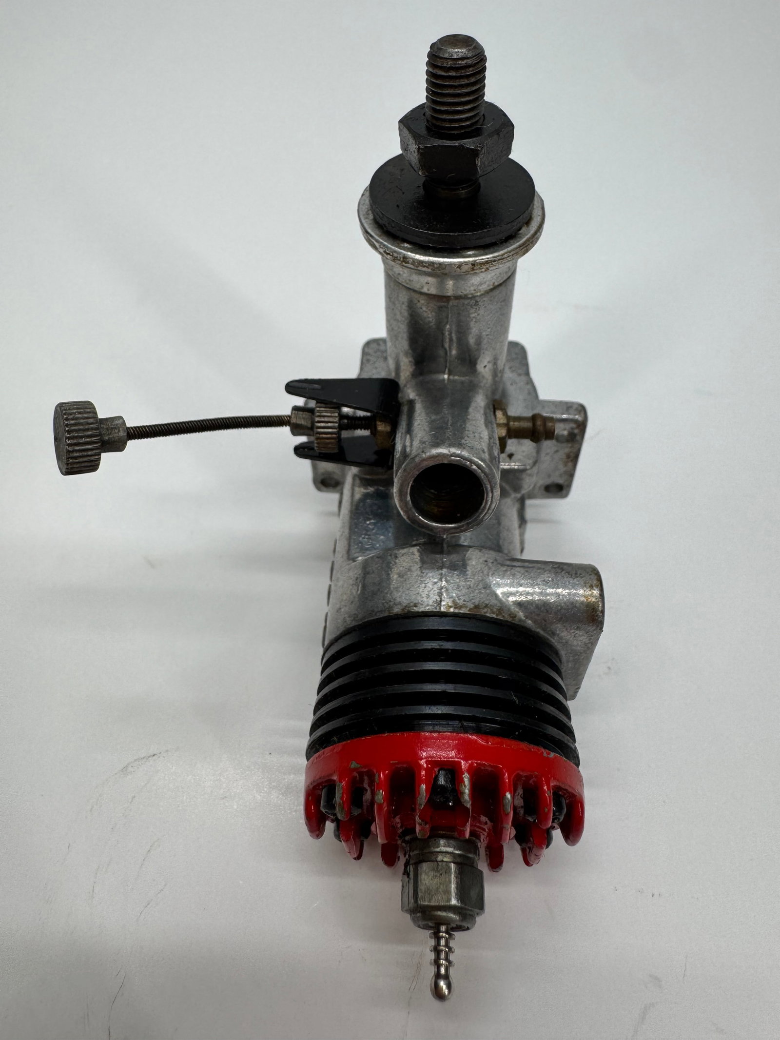 Vintage Model Airplane Glow Engine 200-3: Vintage single-cylinder model airplane glow engine marked 200-3 on the crankcase. Features a finned black cylinder head, aluminum crankcase, needle valve assembly, and glow plug. Designed for use in c