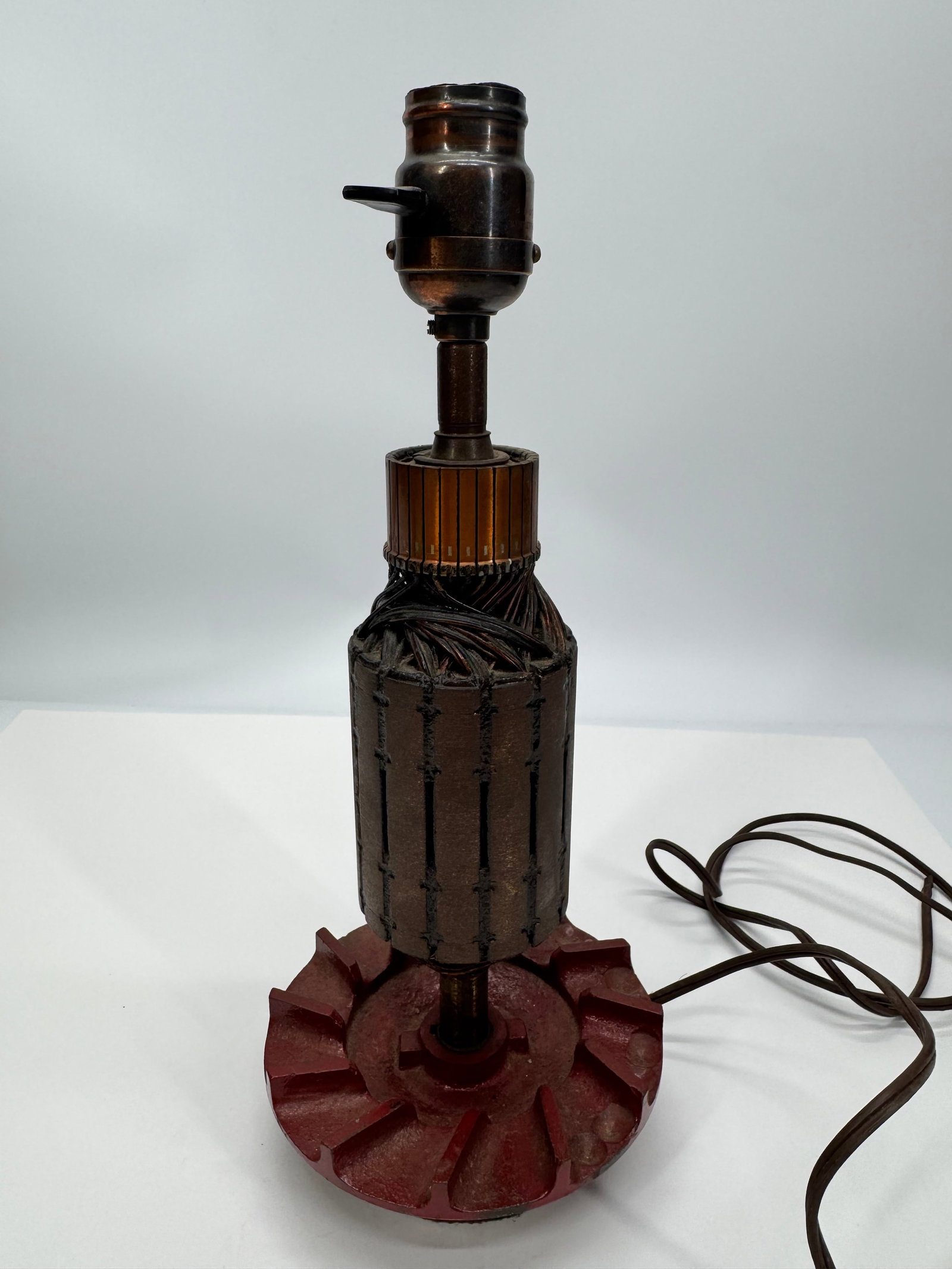 Vintage Industrial Electric Motor Armature Table Lamp: Unique vintage industrial table lamp handcrafted from a large electric motor armature (rotor) with exposed copper windings and a heavy cast-iron base. Features a vintage-style metal socket with rotary