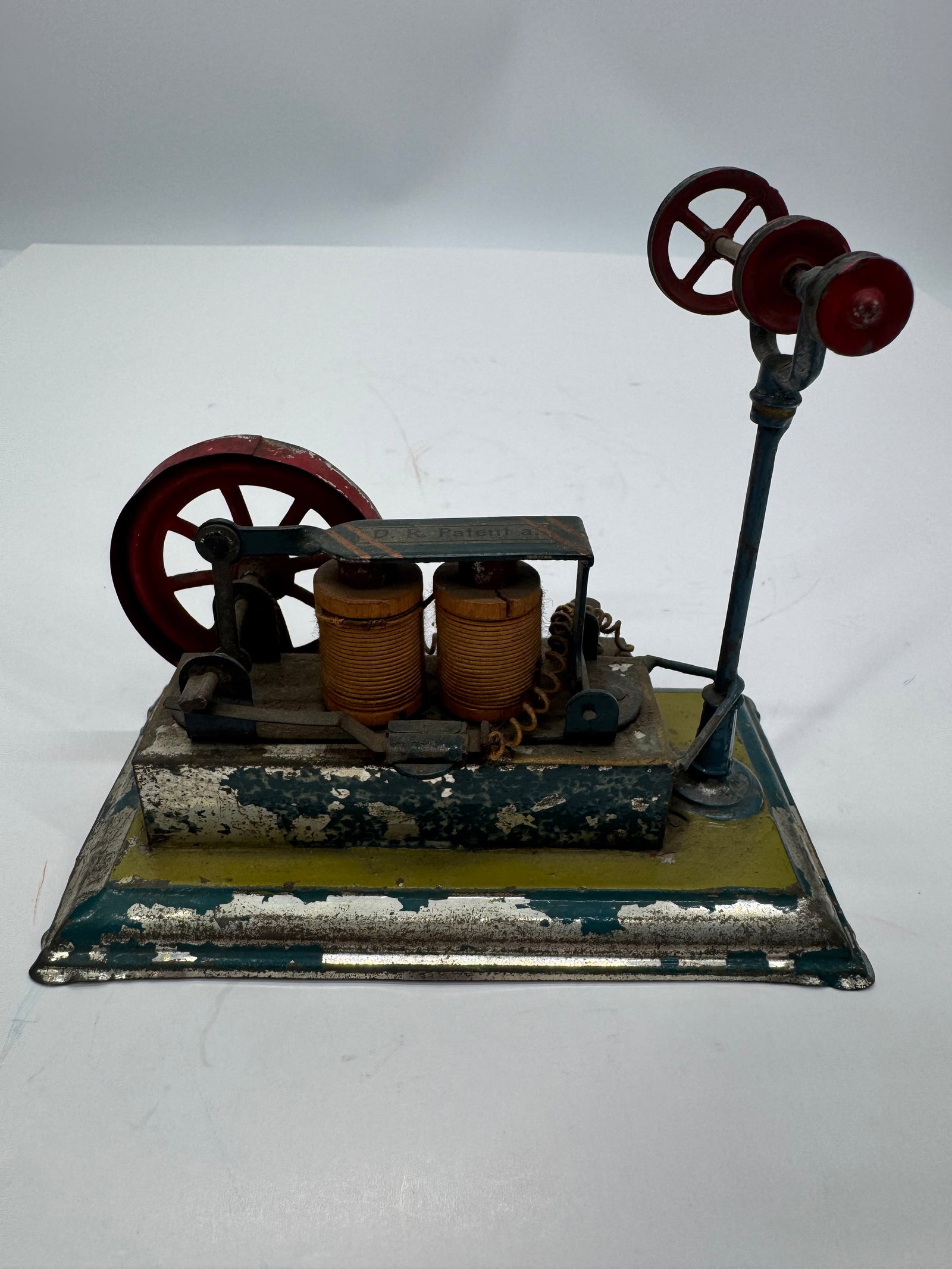 Antique German D.R. Patent Toy Electric Motor Line Shaft: Antique German D.R. Patent toy electric motor and line shaft demonstration model, circa 1910s–1920s. Features twin field coils, a red cast flywheel, overhead line shaft with pulleys, and a painted p