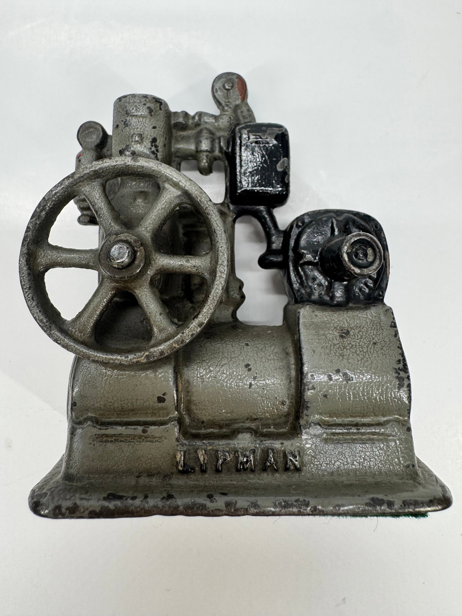 Vintage Lipman Water Pump/Compressor Paperweight: Vintage cast metal Lipman paperweight modeled after an early water pump or air compressor. Features a detailed industrial design with flywheel, cylinder, and raised LIPMAN name cast into the base. A u