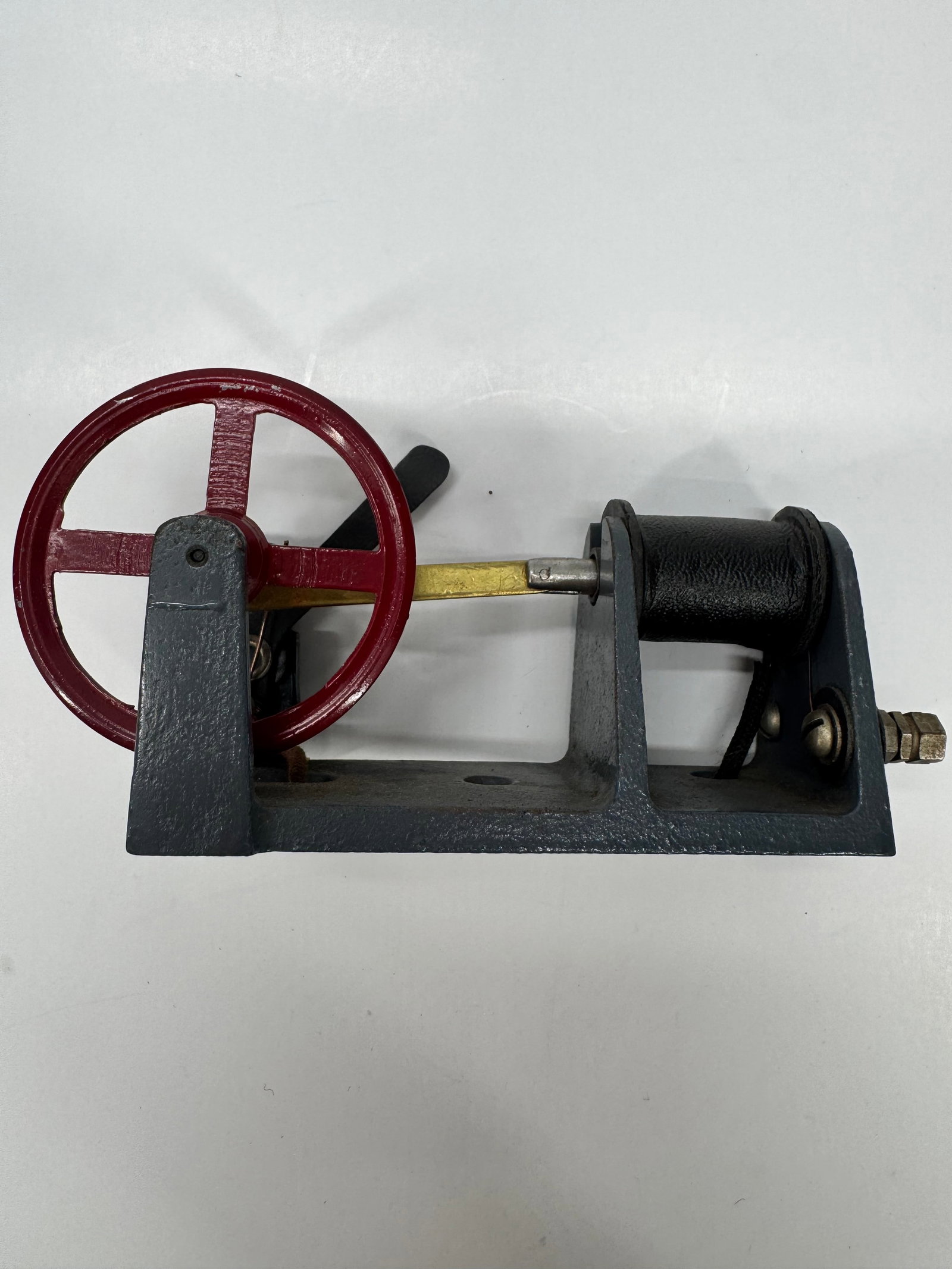 Vintage Cast Iron Oscillating Steam Engine Model w/ Flywheel: Vintage horizontal oscillating steam engine model featuring a cast iron frame, red-painted flywheel, brass connecting rod, and black oscillating cylinder. Designed to operate from an external steam or