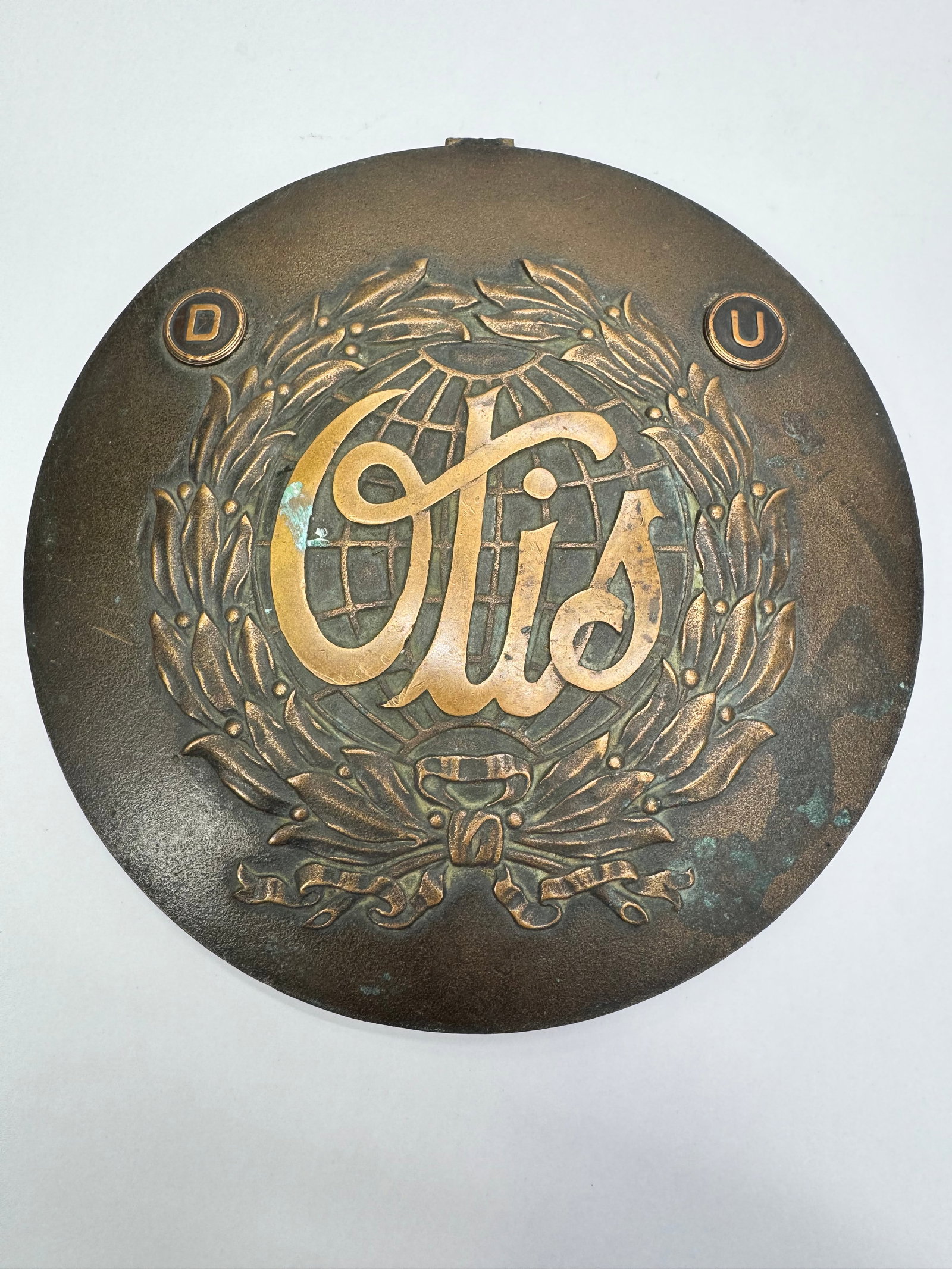 Vintage 1930s Otis Elevator Brass Globe Emblem Badge: Vintage Otis Elevator Company brass emblem dating to the 1930s. Features the iconic globe and laurel leaf design with a rear threaded mounting stud for attachment to elevator equipment or machinery. C