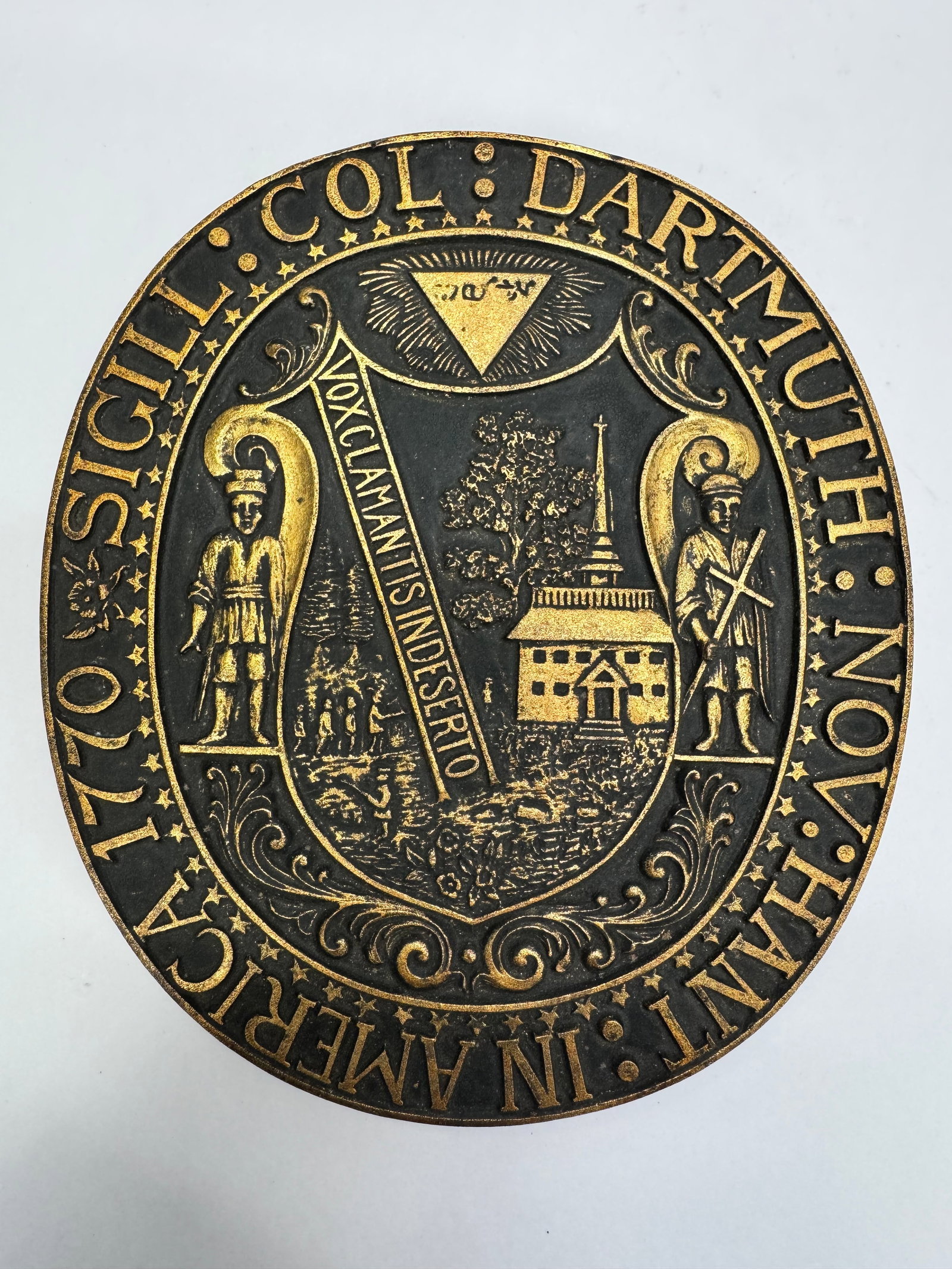 Vintage Dartmouth College Bronze Seal Plaque on Wood Base: Vintage Dartmouth College seal plaque featuring a bronze- or brass-tone relief mounted on a wooden base. The design displays the historic Dartmouth seal with the Latin motto “Vox Clamantis in Desert
