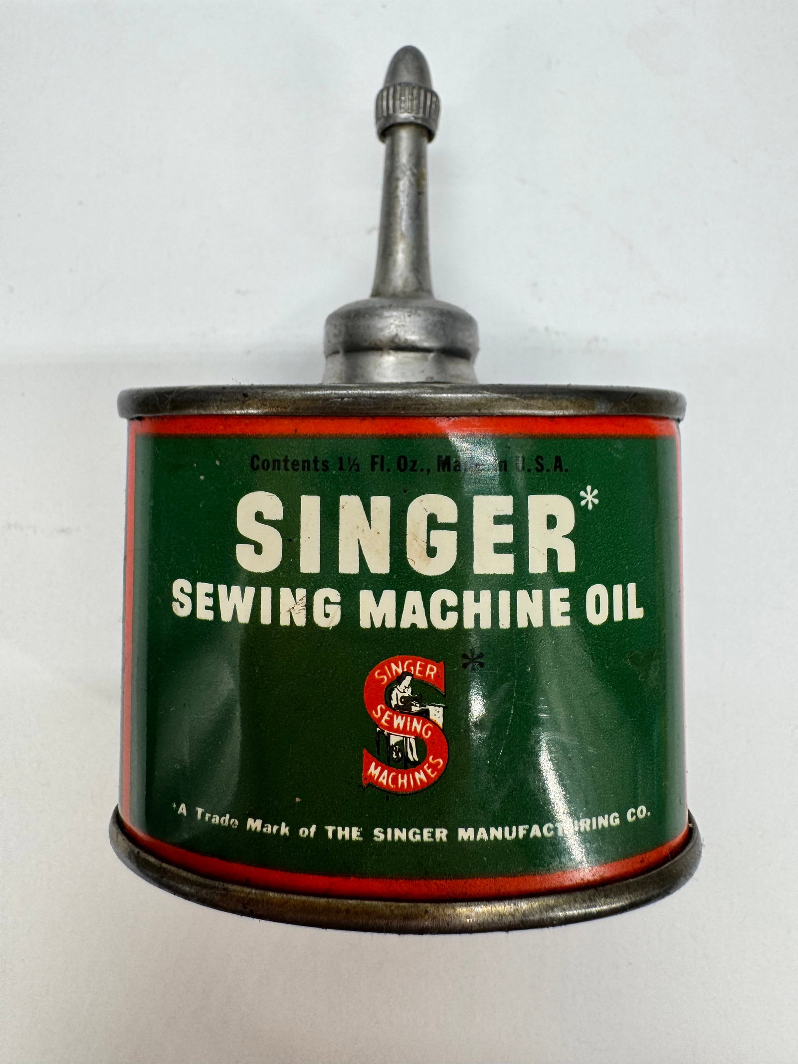 Vintage Singer Sewing Machine Oil 1½ Oz Tin Oiler Lead Top: Vintage Singer Sewing Machine Oil tin oiler with the classic green and red advertising design. Marked Contents 1½ Fl. Oz., this original metal oil can features its lead-top applicator and Singe
