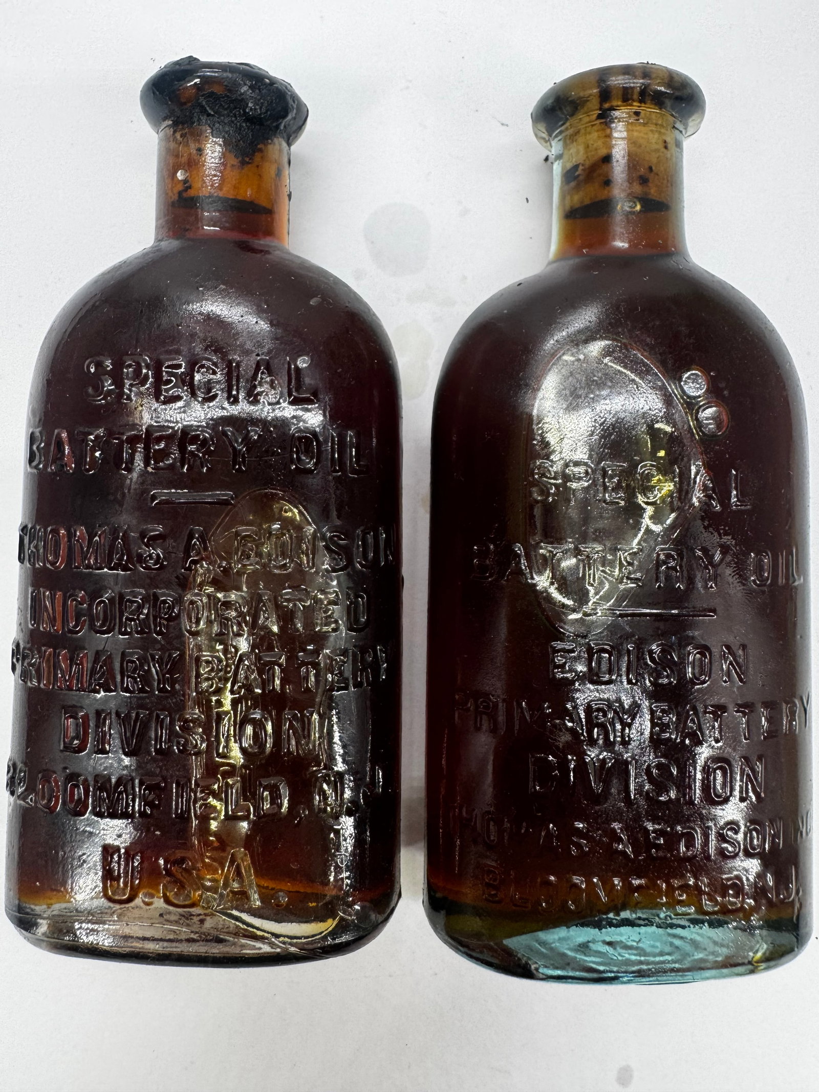 Lot of 2 Antique Thomas A. Edison Special Battery Oil Embossed Glass Bottles: Lot of two antique embossed Thomas A. Edison Special Battery Oil amber glass bottles. One bottle is marked Thomas A. Edison Incorporated, Primary Battery Division, Bloomfield, N.J., U.S.A., while the 