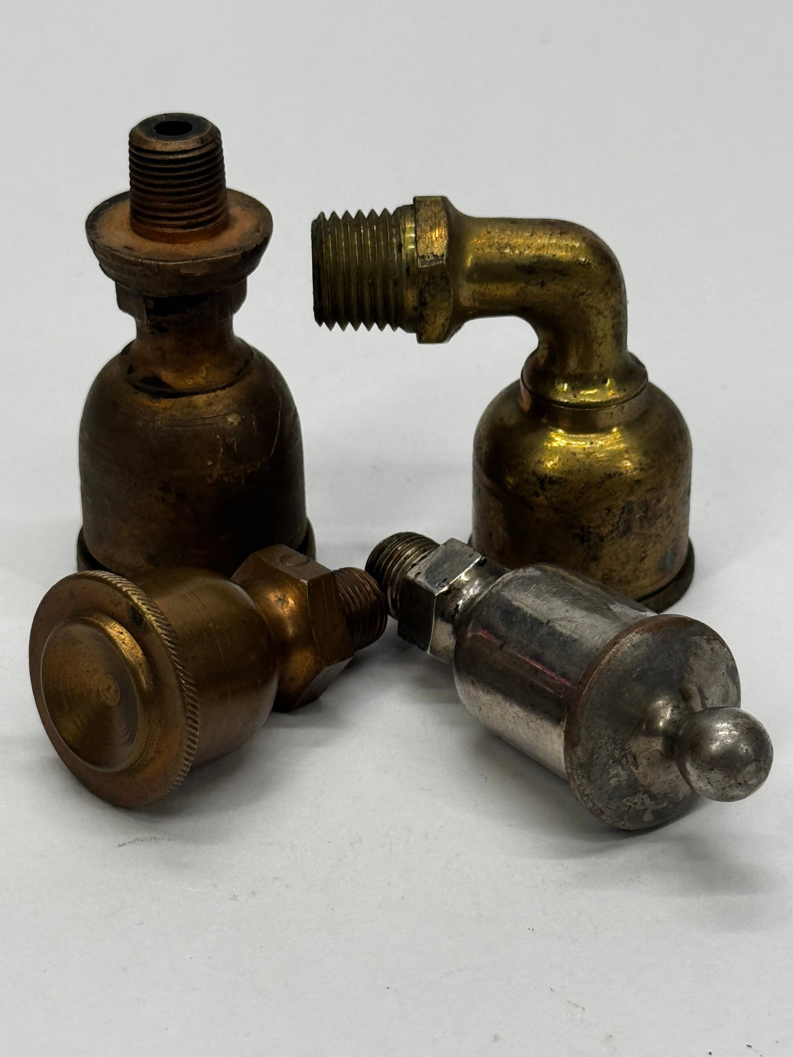 Lot of 4 Antique Brass Steam Engine Lubricators & Grease Cups: Lot of four antique brass lubricators/grease cups for steam engines, hit-and-miss engines, or early industrial machinery. Includes a variety of straight and 90-degree threaded fittings, with one nicke