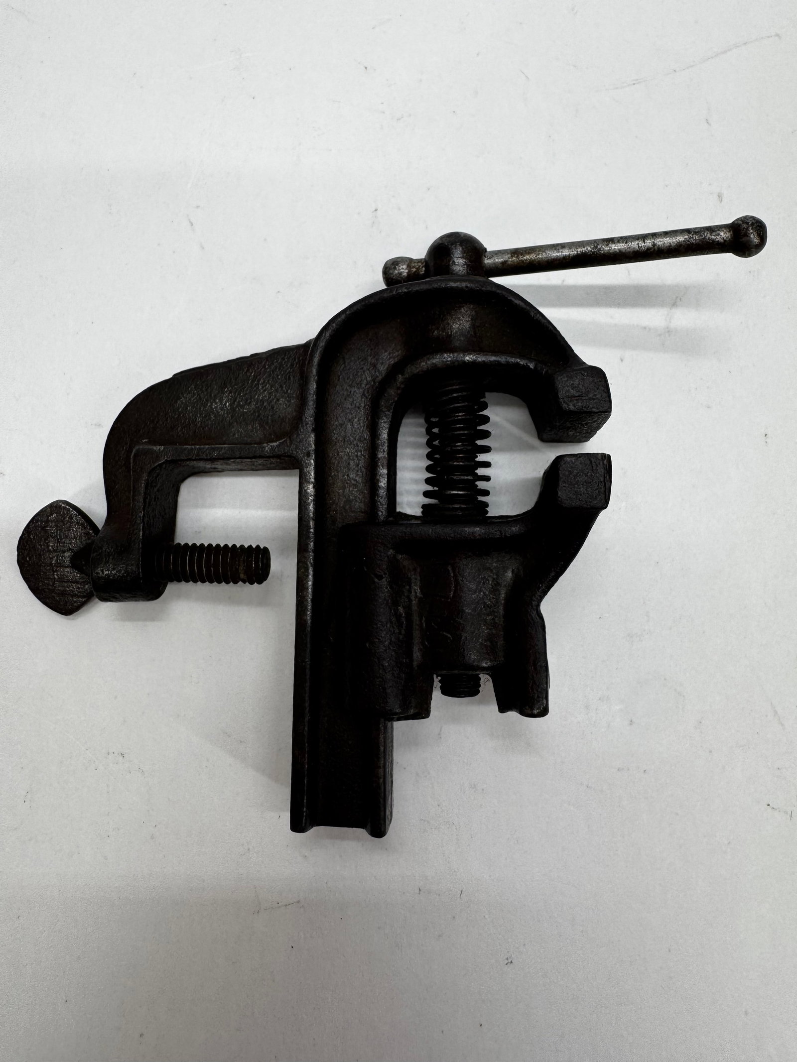 Vintage Watchmaker Jeweler Bench Vise Cast Iron: Vintage cast iron watchmaker’s or jeweler’s bench vise with a table clamp for secure mounting. Features small precision jaws for holding watches, jewelry, and other delicate workpieces during repa