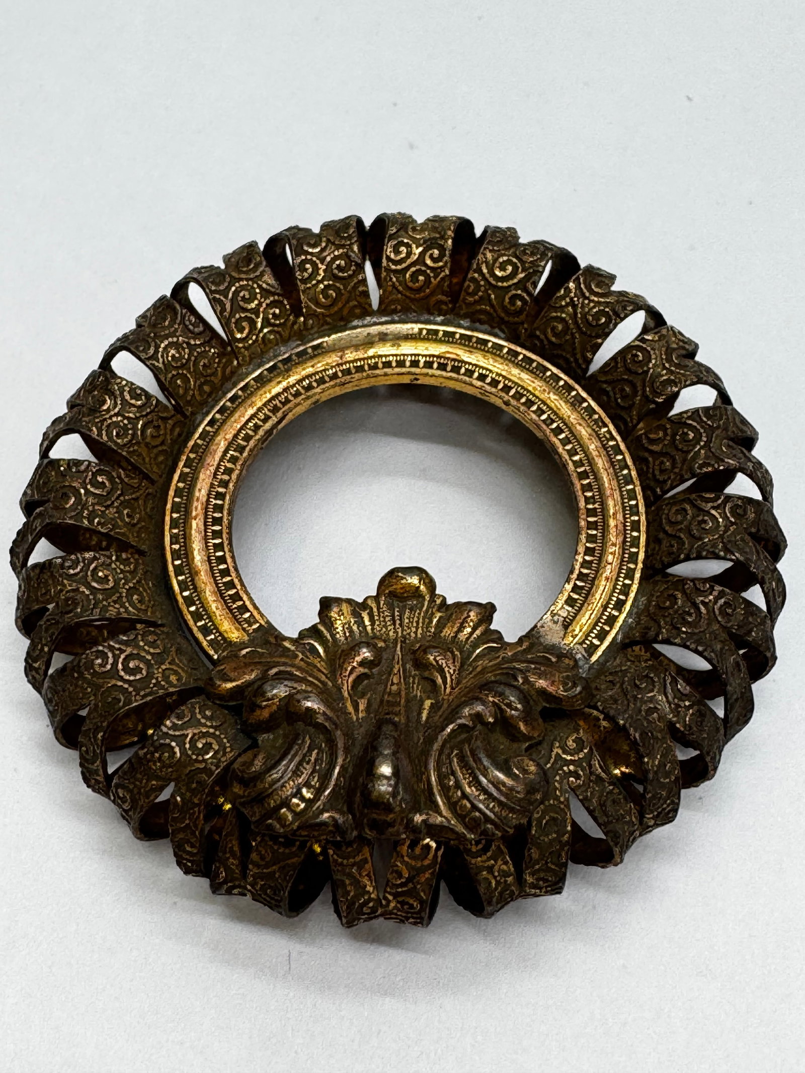 Antique Ornate Brass Miniature Portrait Frame Bezel 2.5”: Antique ornate stamped brass miniature portrait frame bezel measuring approximately 2.5 inches in diameter with a 1.25-inch inner opening. Features 24 embossed ribbon-scroll loops surrounding a cast a
