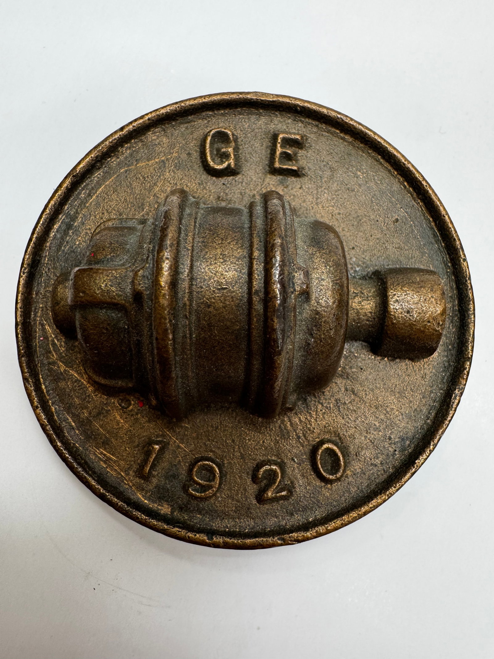 Vintage GE 1920 Motor Armature Cast Iron Paperweight: Vintage General Electric (GE) cast iron promotional paperweight featuring a raised GE logo, “1920” date, and an early electric motor armature/rotor design. This industrial advertising desk acc