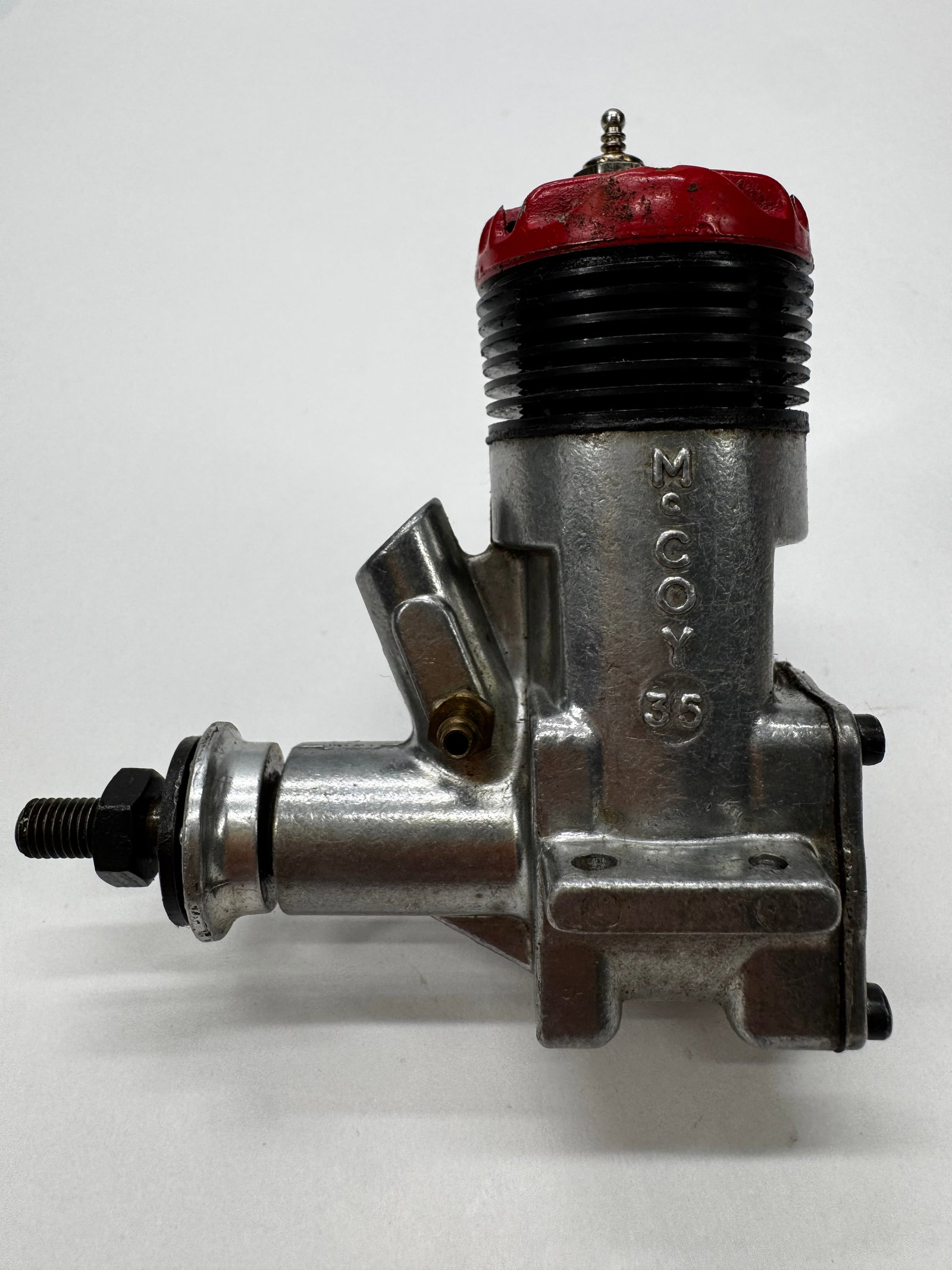 Vintage McCoy .35 Glow Model Airplane Engine RC Motor: Vintage McCoy .35 glow fuel model airplane engine with its distinctive red cylinder head and cast aluminum crankcase. A classic American-made engine popular for control line and early RC aircraft. App