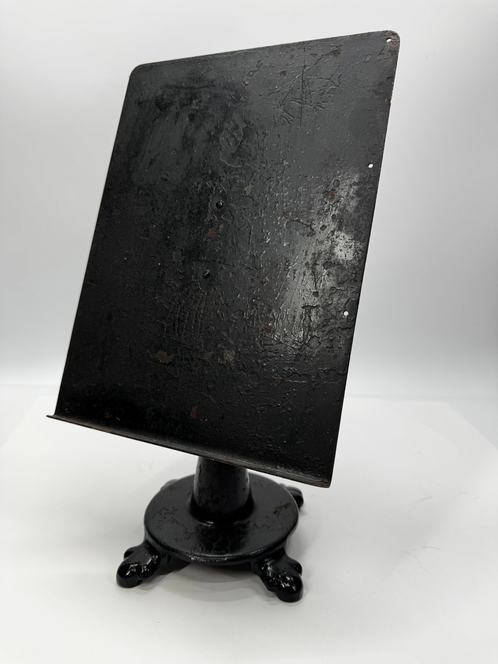 Antique Cast Iron Adjustable Display Stand: Antique cast iron tabletop display stand featuring a heavy four-foot base and an adjustable tilting metal display panel. Originally used for displaying sheet music, catalogs, signs, menus, or sales li