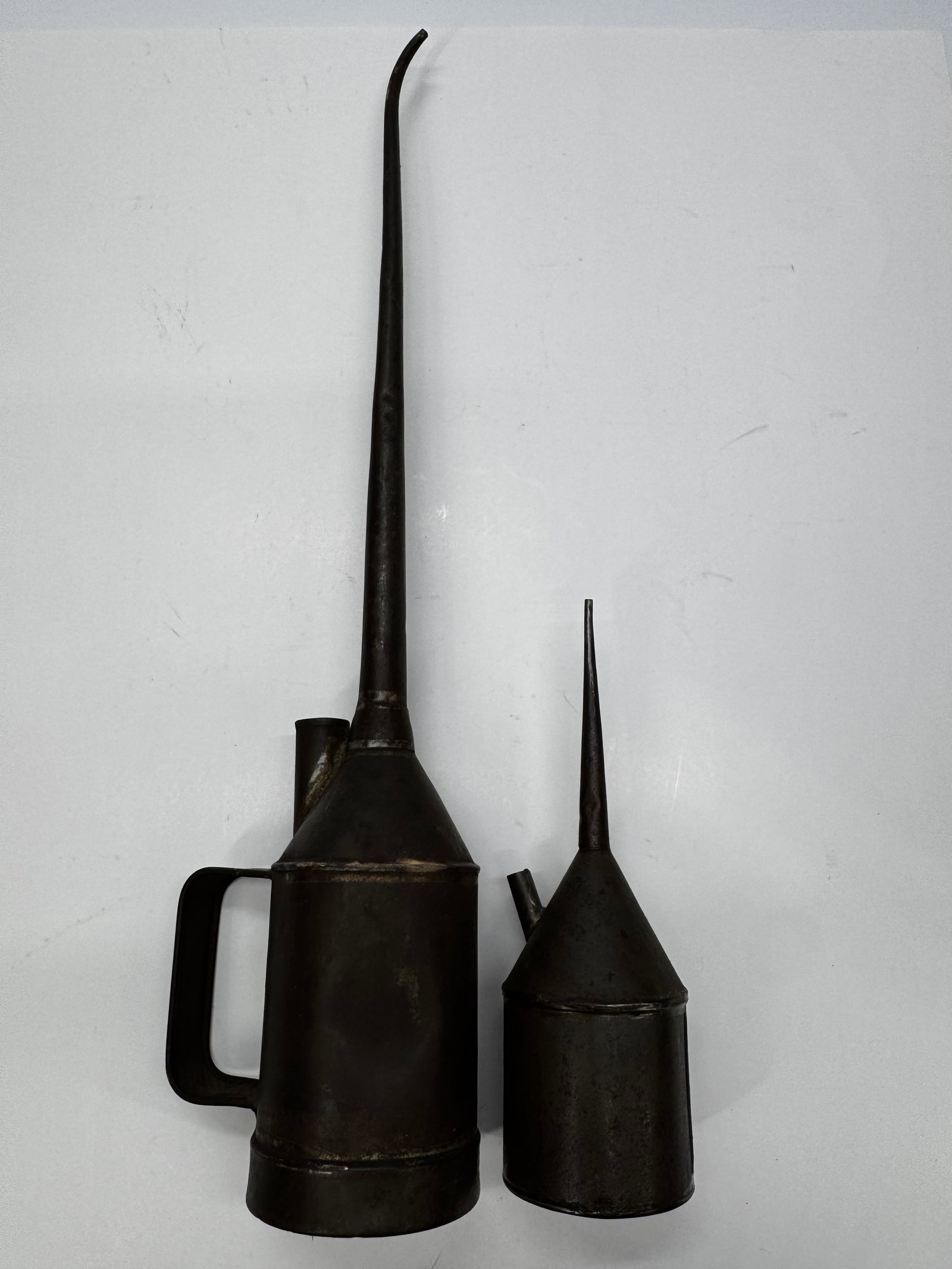 Vintage Metal Pump Oil Cans Lot of 2: Lot of two vintage metal pump oil cans with long tapered spouts and side fill openings. These industrial lubricating cans were commonly used for machine tools, steam engines, farm equipment, and early