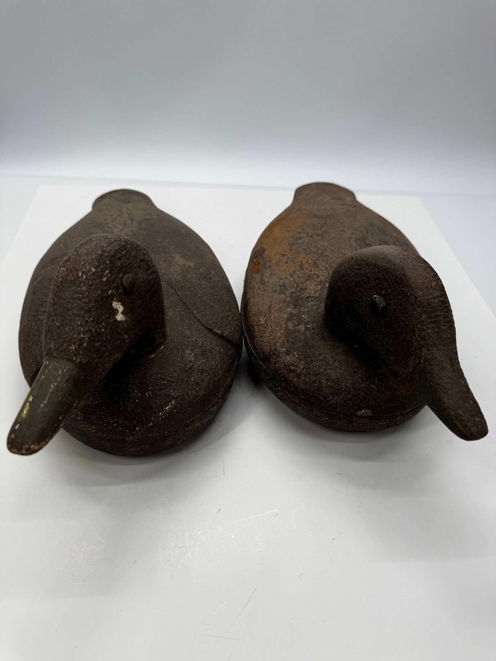 Antique Hand Carved Wooden Duck Decoys Pair: Pair of antique hand-carved wooden duck decoys with solid carved bodies and elongated bills. Each features carved wing details, painted eyes, and an aged original finish with authentic hunting wear, p
