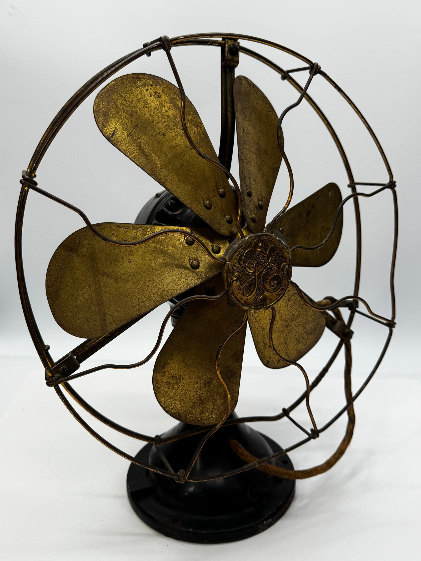 Antique General Electric GE 6-Blade Brass Desk Fan Original Tag 110V Early AC: Antique General Electric (GE) alternating current desk fan featuring six original brass blades, an open brass wire cage, and a heavy cast iron base with original black finish. The motor retains its or